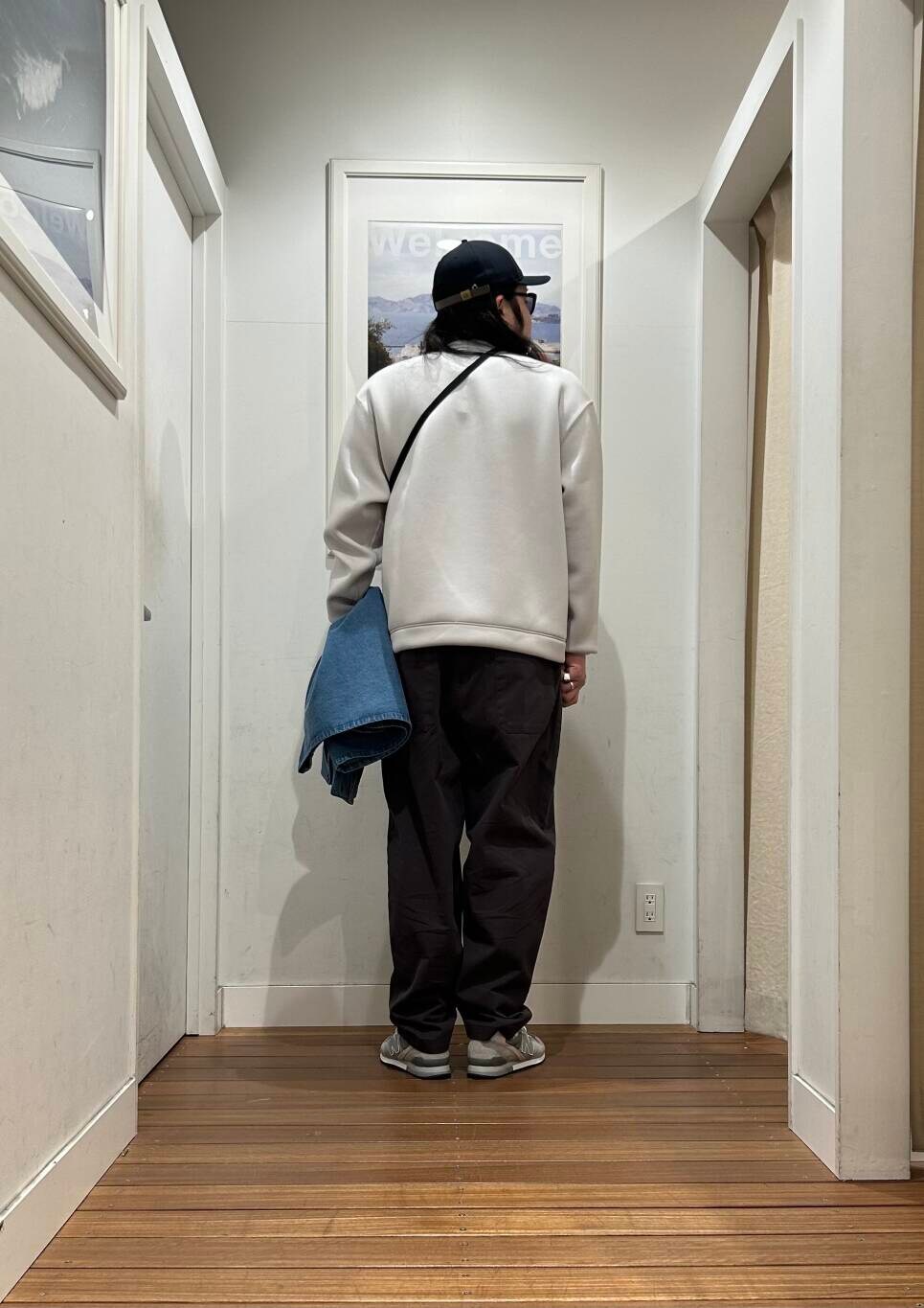 ブラック系のショルダーバッグ、ブルー系のカバーオール、グレー系のスニーカーを着用したメンズの冬コーディネートの4枚目の写真