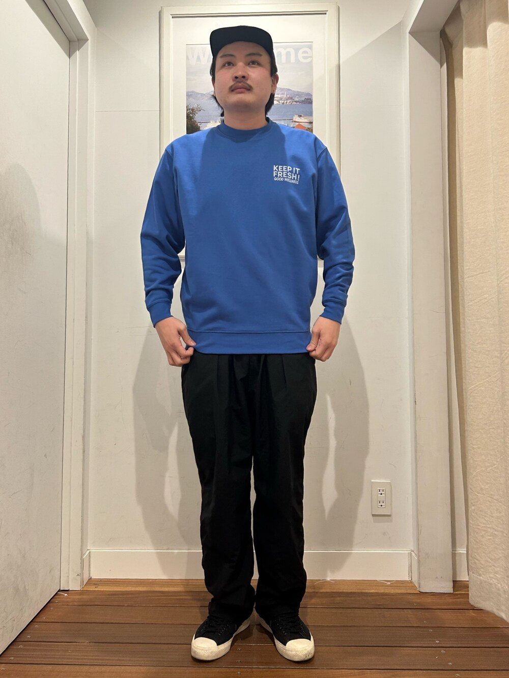 ブルー系のスウェット、ブラック系のパンツ、ブラック系のスニーカーを着用したメンズの春コーディネートの4枚目の写真