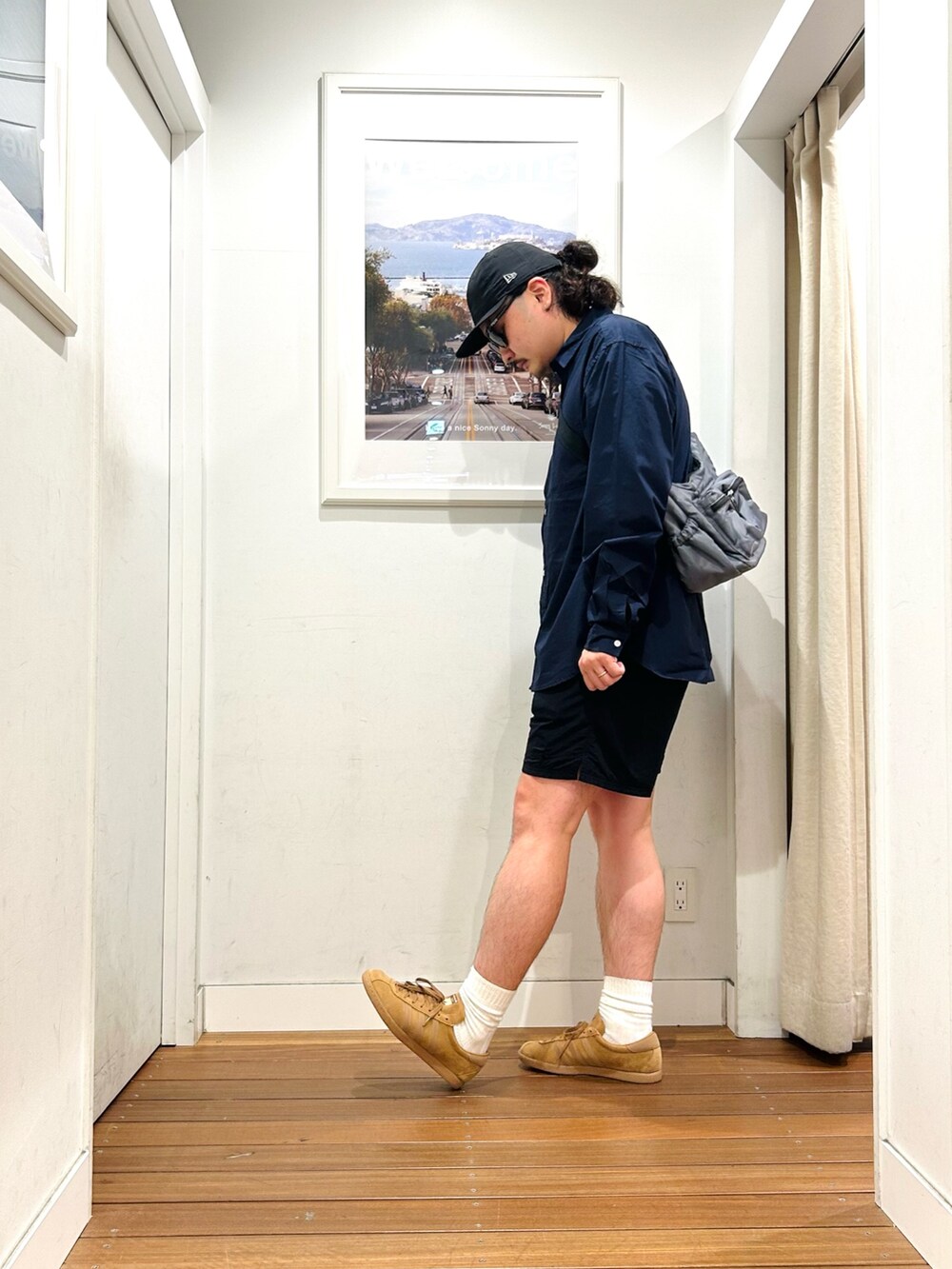 グレー系のショルダーバッグ、ブルー系のシャツ/ブラウス、ブラウン系のスニーカーを着用したメンズの秋コーディネートの2枚目の写真