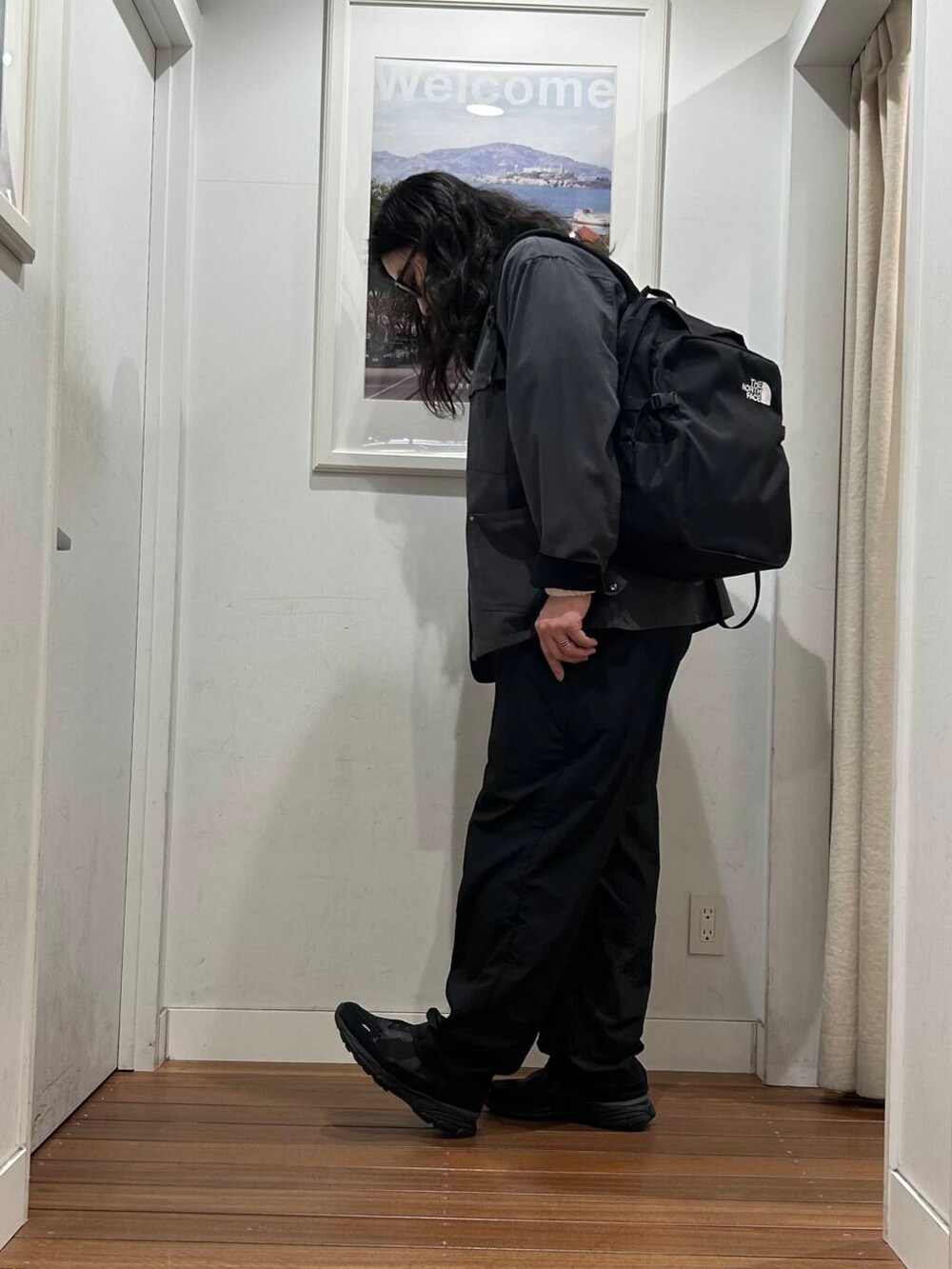 グレー系のカバーオール、ブラック系のバックパック/リュック、ブラック系のスニーカーを着用したメンズの秋コーディネートの2枚目の写真