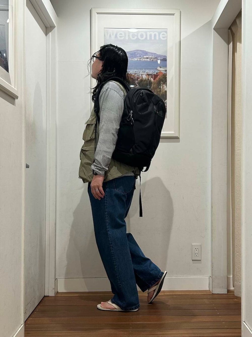 ホワイト系のサンダル、ブラック系のTシャツ/カットソー、グリーン系のベストを着用したメンズの夏コーディネートの3枚目の写真