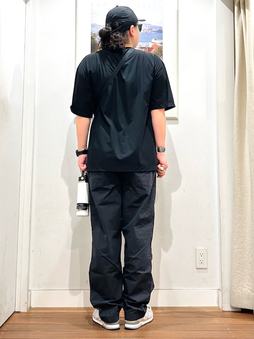 ブラック系のTシャツ/カットソー、ブラック系のショルダーバッグ、ホワイト系のタンクトップを着用したメンズの夏コーディネートの4枚目の写真