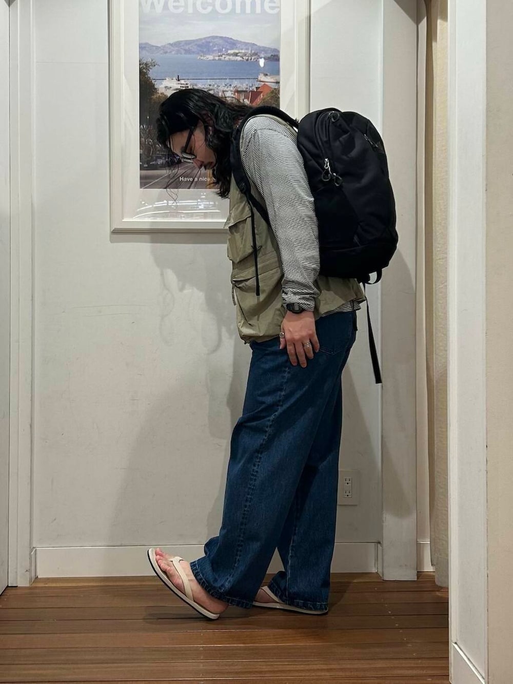 ホワイト系のサンダル、ブラック系のTシャツ/カットソー、グリーン系のベストを着用したメンズの夏コーディネートの2枚目の写真