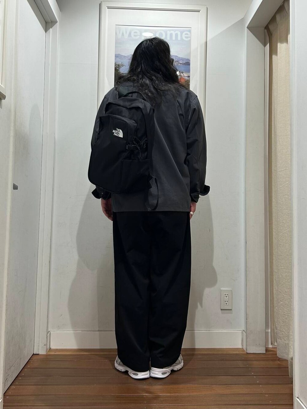 ブラック系のその他パンツ、オレンジ系のTシャツ/カットソー、グレー系のスニーカーを着用したメンズの秋コーディネートの4枚目の写真