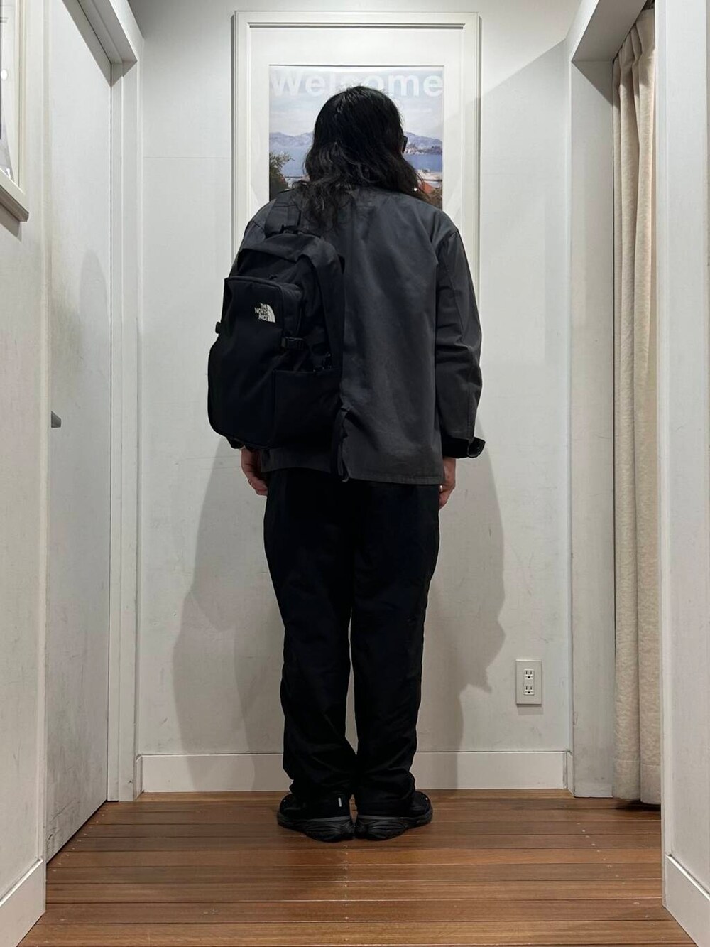 グレー系のカバーオール、ブラック系のバックパック/リュック、ブラック系のスニーカーを着用したメンズの秋コーディネートの4枚目の写真