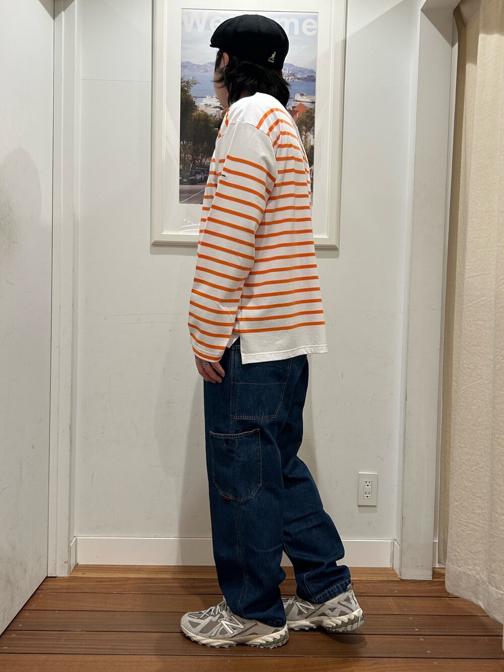 オレンジ系のTシャツ/カットソー、ブルー系のデニムパンツ、グレー系のスニーカーを着用したメンズの春コーディネートの2枚目の写真