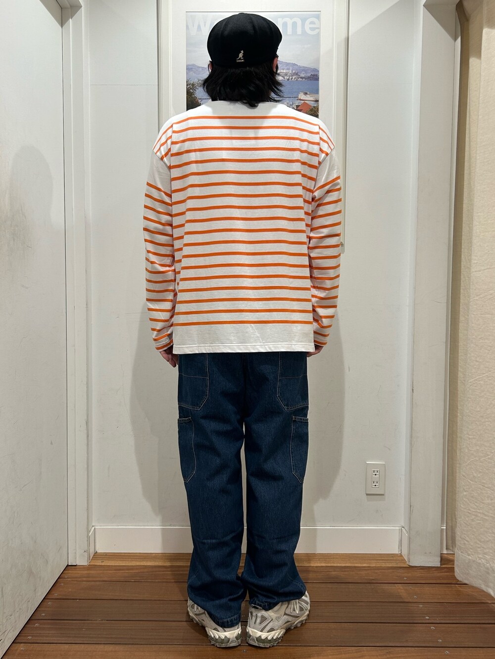 オレンジ系のTシャツ/カットソー、ブルー系のデニムパンツ、グレー系のスニーカーを着用したメンズの春コーディネートの3枚目の写真