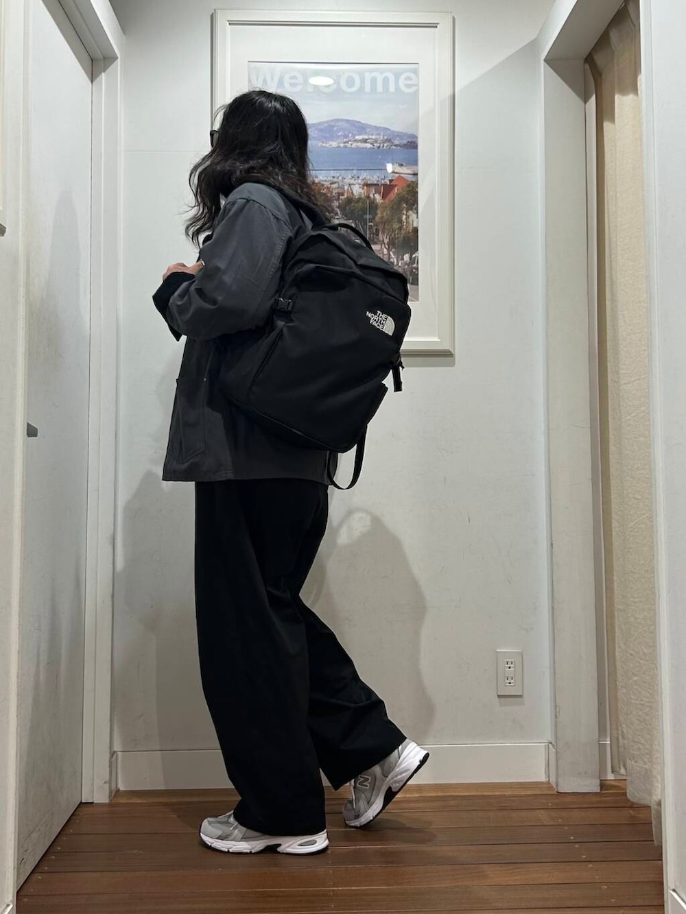 ブラック系のその他パンツ、オレンジ系のTシャツ/カットソー、グレー系のスニーカーを着用したメンズの秋コーディネートの3枚目の写真