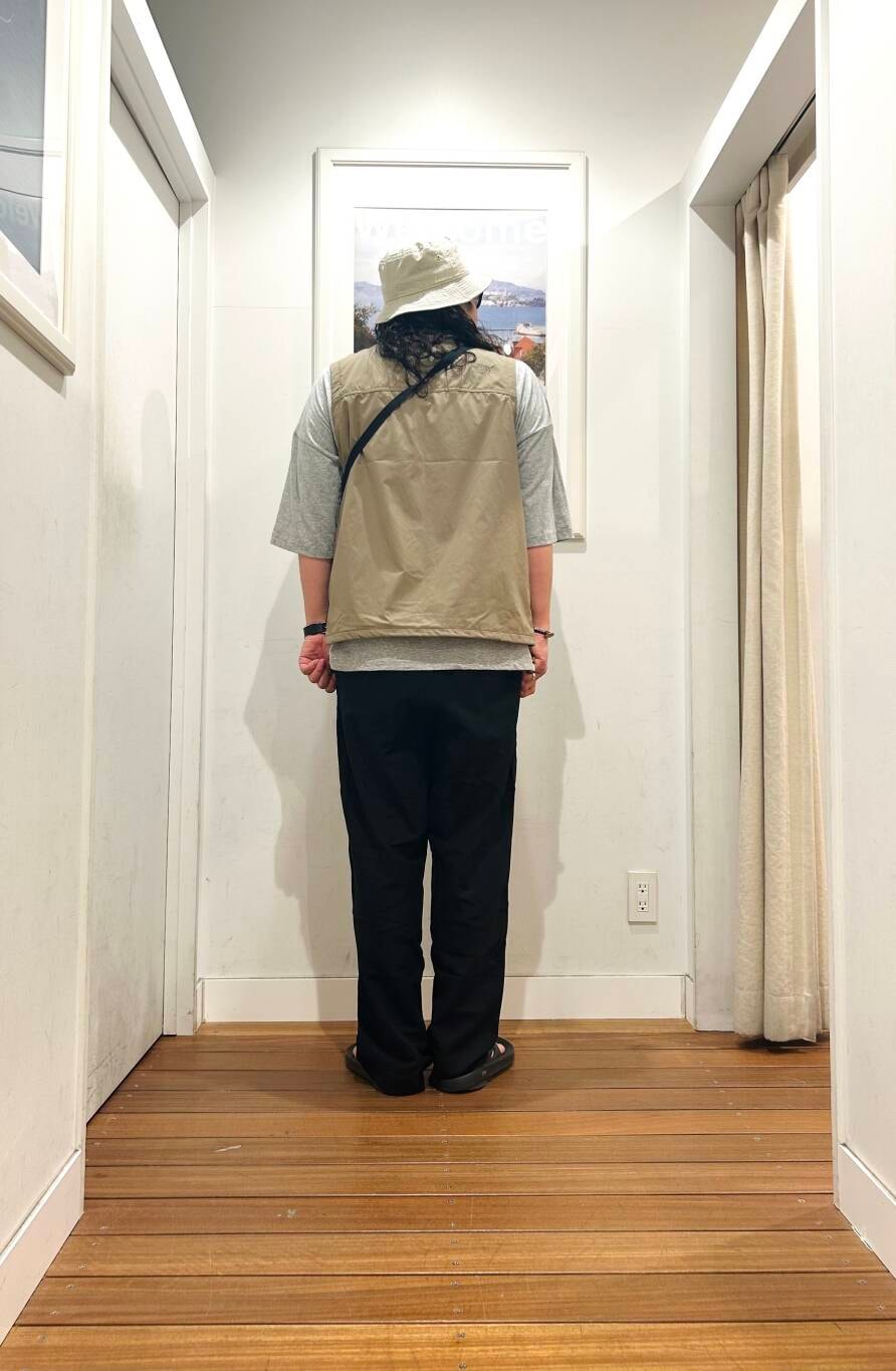 ブラック系のサンダル、グレー系のショルダーバッグ、ベージュ系のベストを着用したメンズの春コーディネートの4枚目の写真