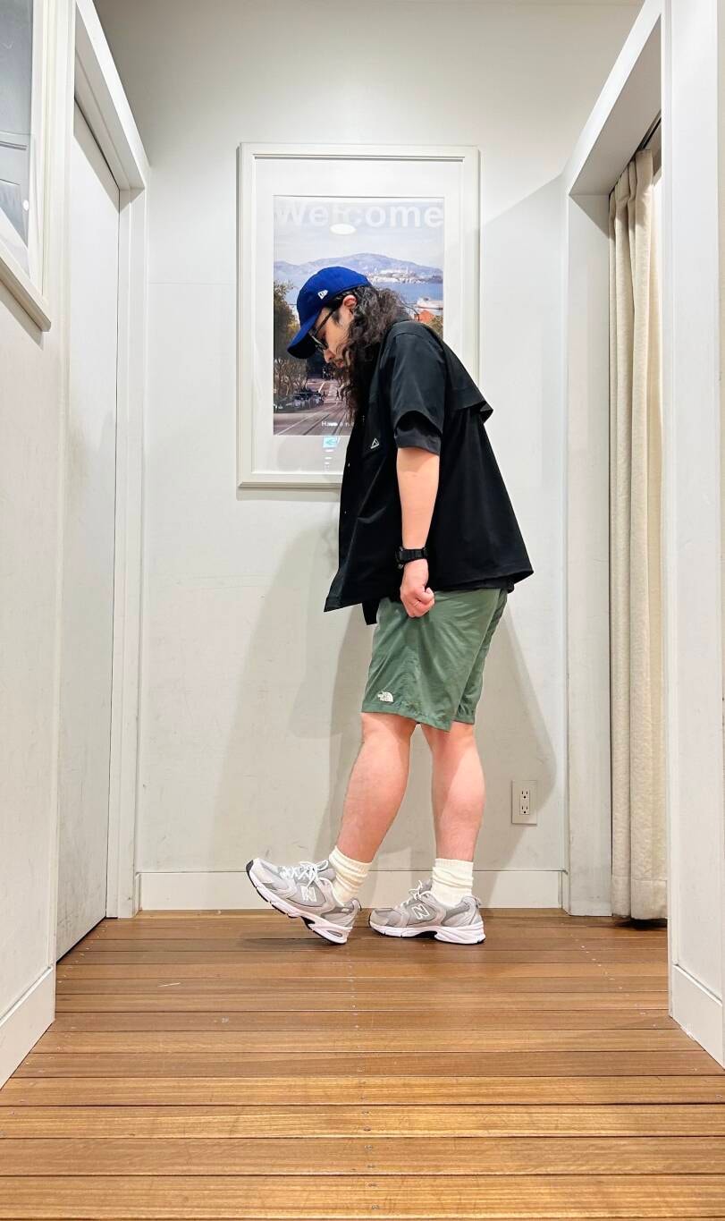 グリーン系のその他パンツ、グレー系のスニーカー、ブラック系のショルダーバッグを着用したメンズの春コーディネートの2枚目の写真