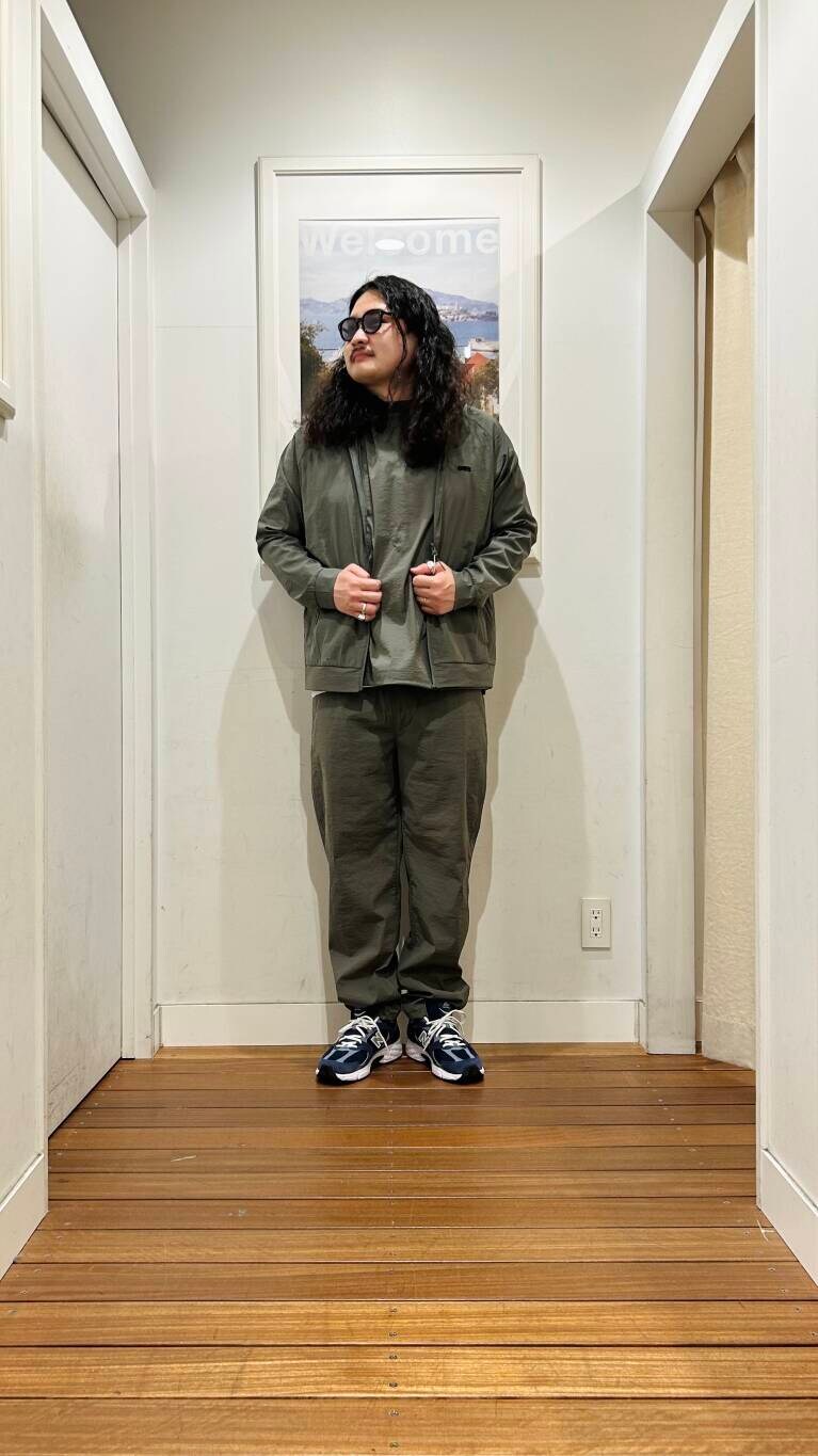 ブルー系のスニーカー、ブラック系のショルダーバッグ、グリーン系のブルゾンを着用したメンズの春コーディネートの5枚目の写真