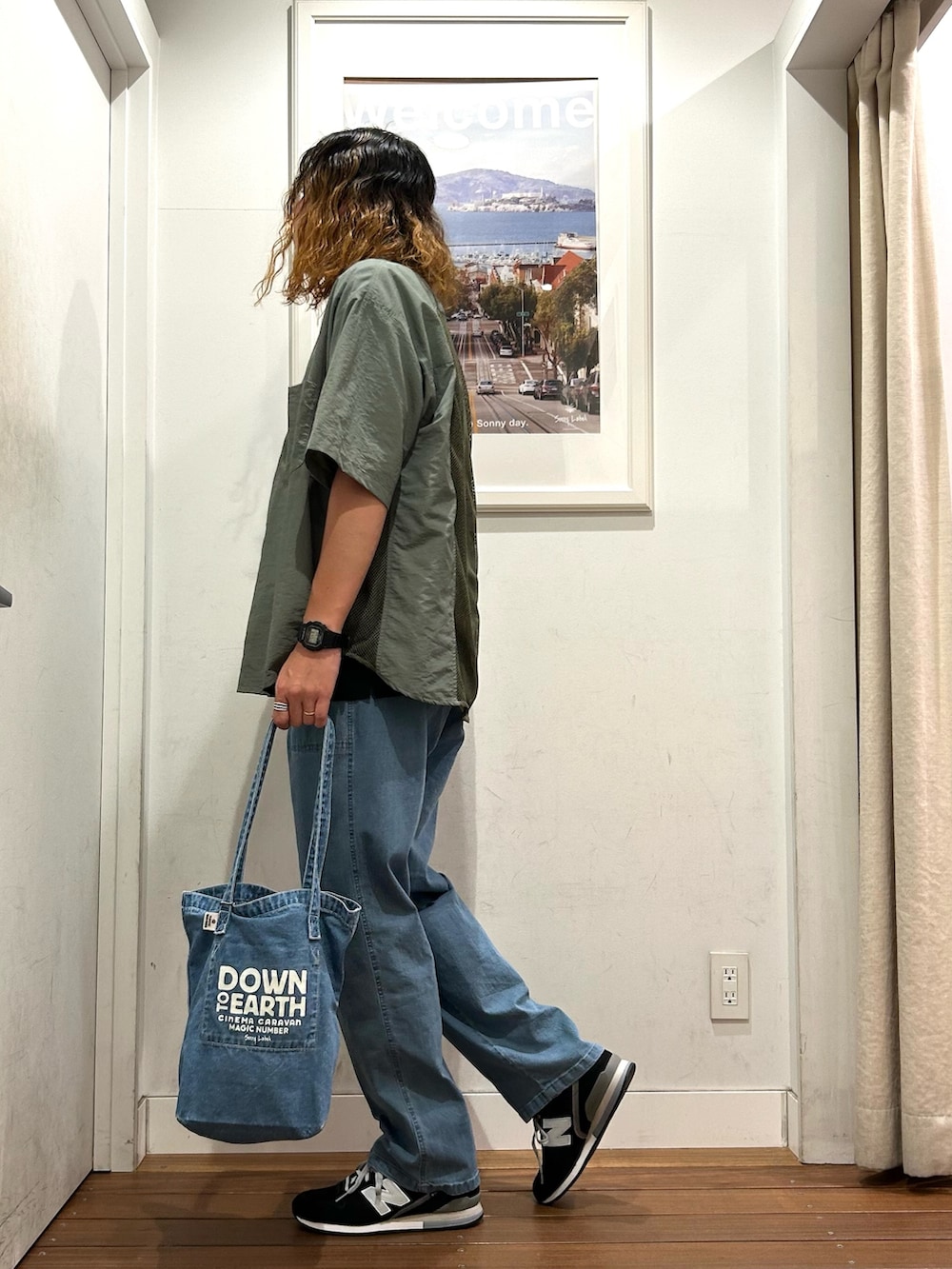 ブラック系のスニーカー、ブラック系のTシャツ/カットソー、ブルー系のデニムパンツを着用したメンズの春コーディネートの3枚目の写真