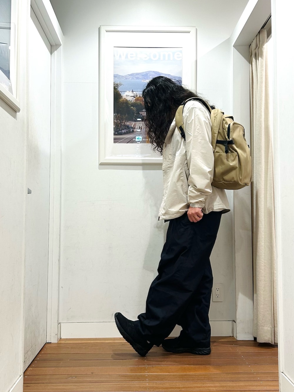 グリーン系のバックパック/リュック、ホワイト系のTシャツ/カットソー、ホワイト系のナイロンジャケットを着用したメンズの秋コーディネートの2枚目の写真