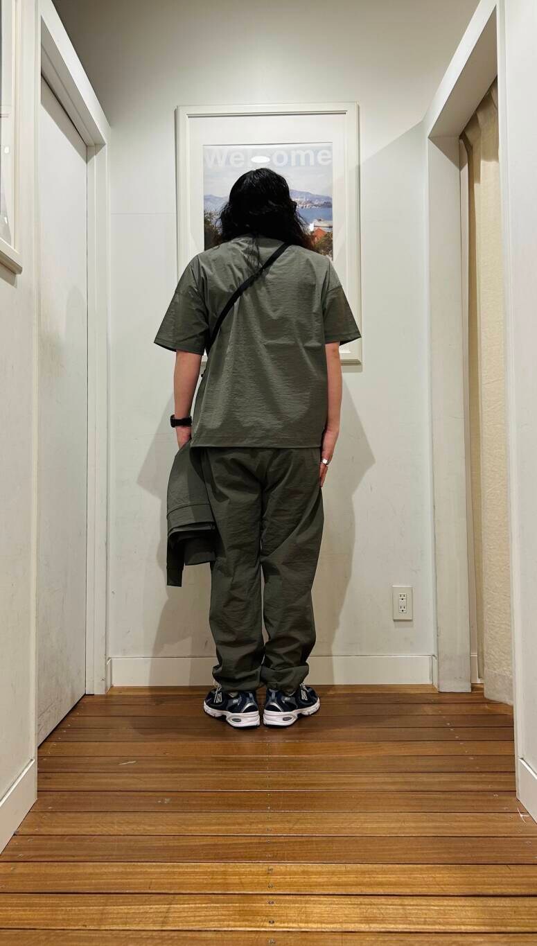 ブルー系のスニーカー、ブラック系のショルダーバッグ、グリーン系のブルゾンを着用したメンズの春コーディネートの4枚目の写真