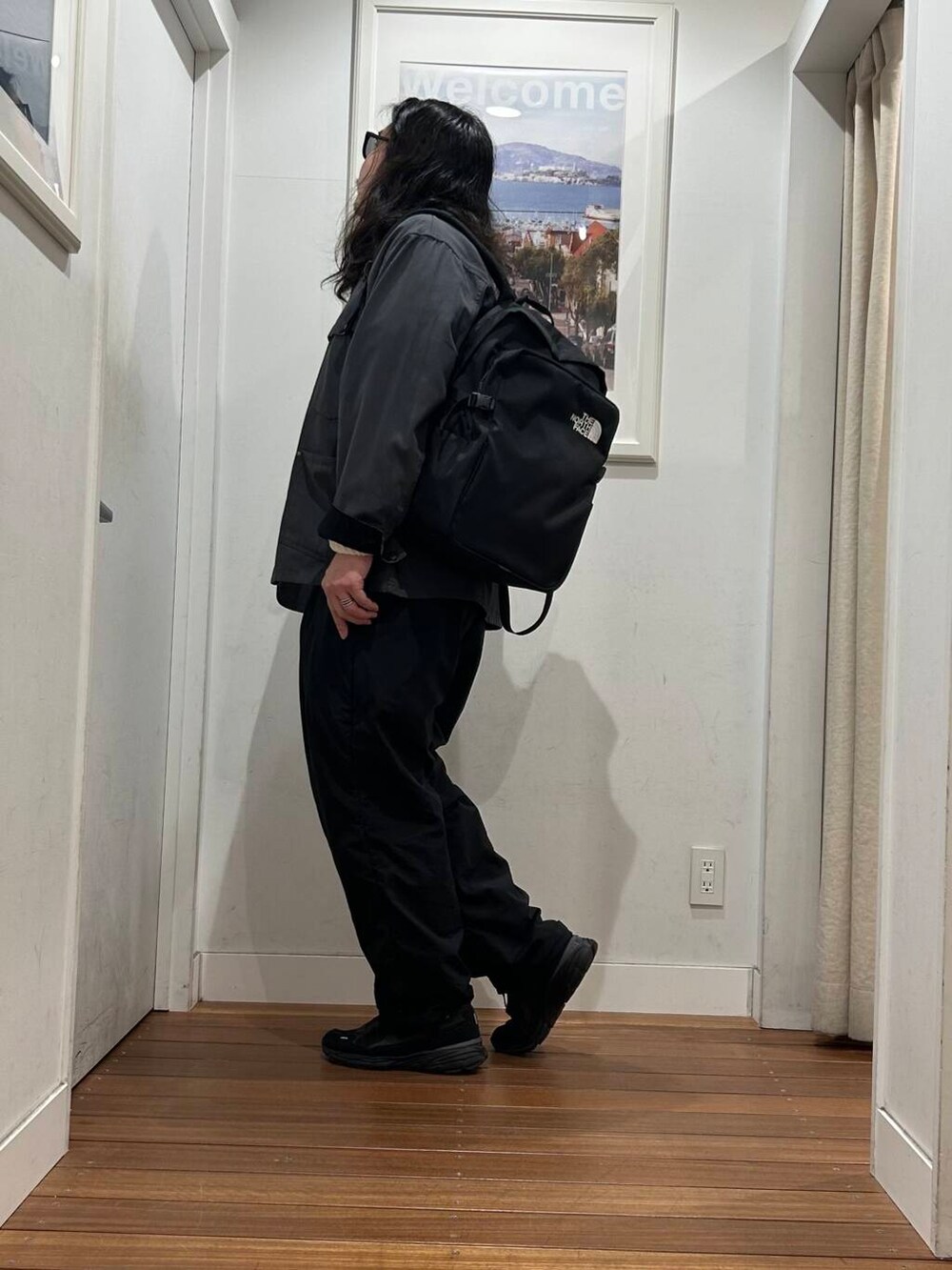 グレー系のカバーオール、ブラック系のバックパック/リュック、ブラック系のスニーカーを着用したメンズの秋コーディネートの3枚目の写真