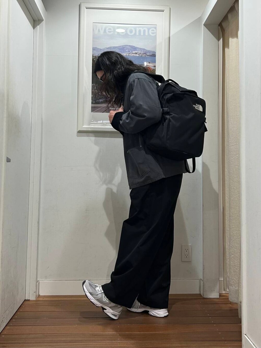 ブラック系のその他パンツ、オレンジ系のTシャツ/カットソー、グレー系のスニーカーを着用したメンズの秋コーディネートの2枚目の写真