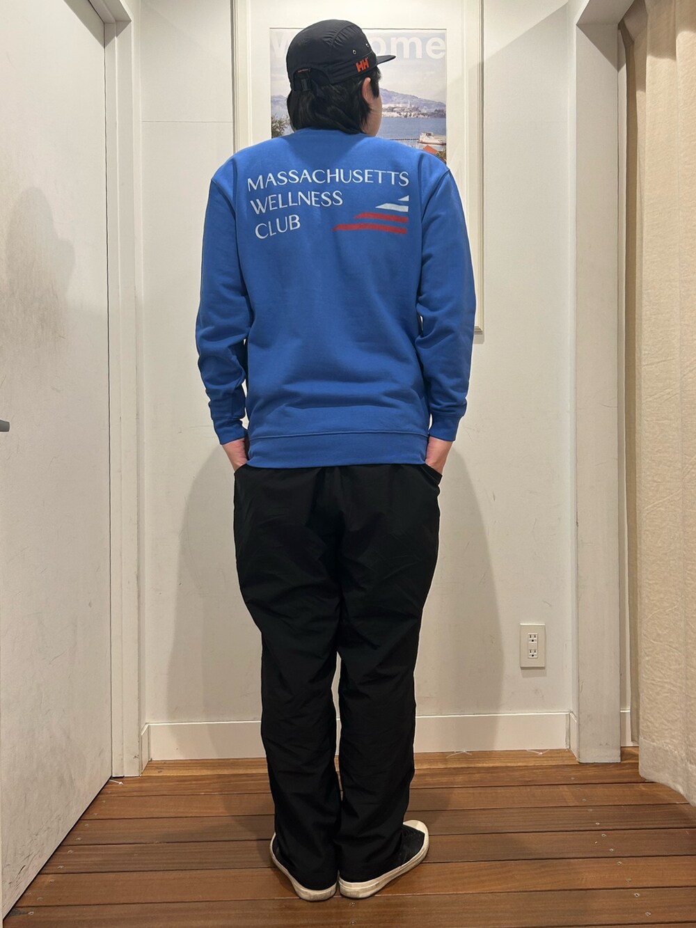 ブルー系のスウェット、ブラック系のパンツ、ブラック系のスニーカーを着用したメンズの春コーディネートの5枚目の写真