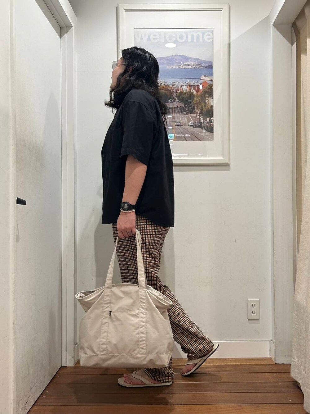 ホワイト系のサンダル、ベージュ系のその他パンツ、ベージュ系のトートバッグを着用したメンズの夏コーディネートの3枚目の写真