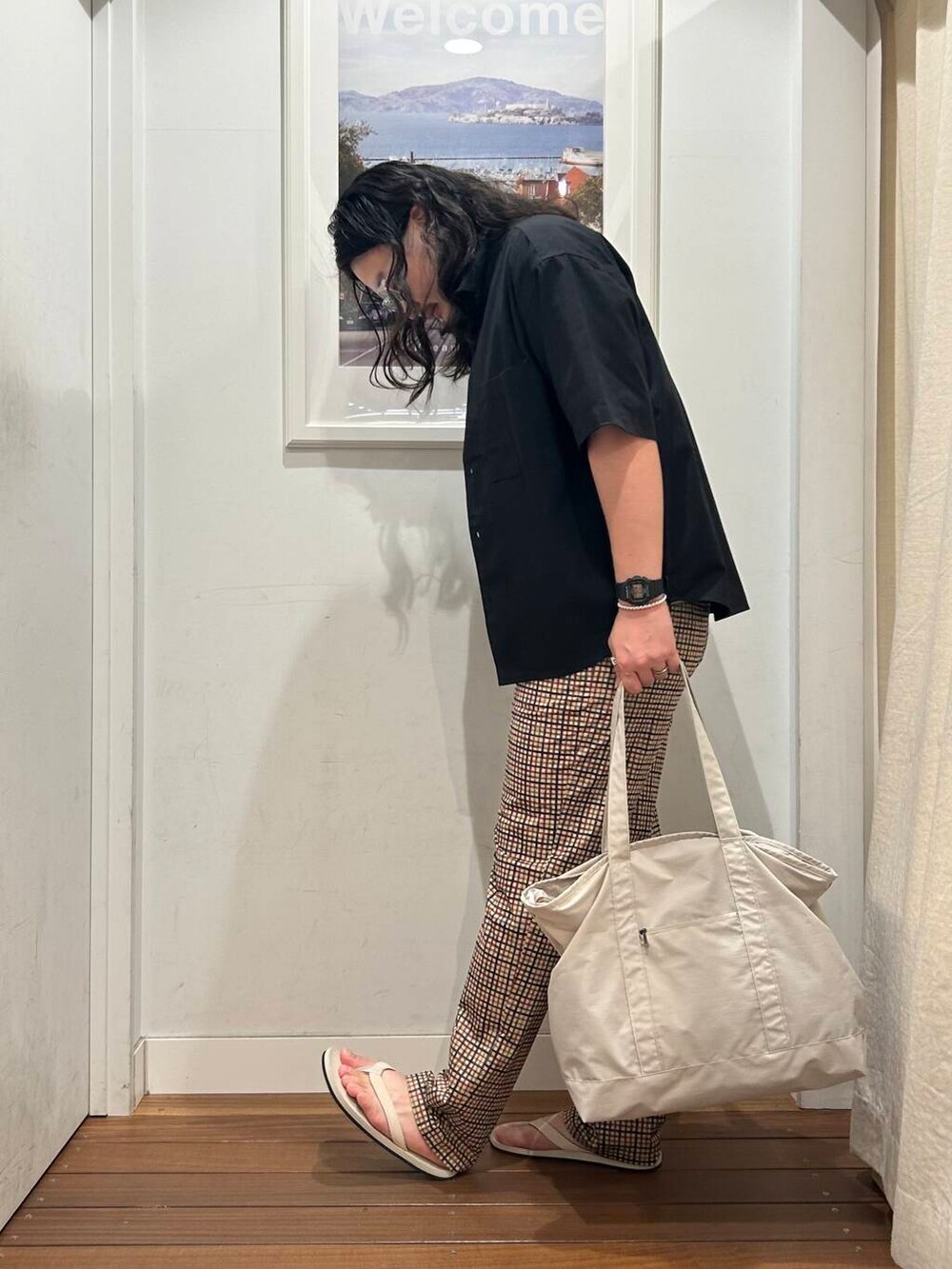 ホワイト系のサンダル、ベージュ系のその他パンツ、ベージュ系のトートバッグを着用したメンズの夏コーディネートの2枚目の写真