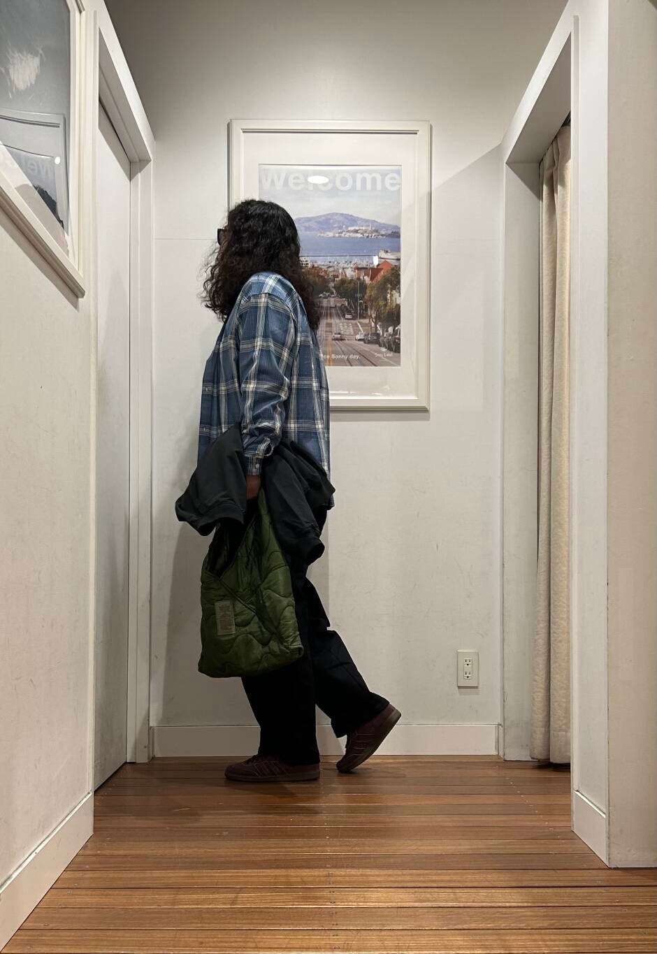 ブラウン系のスニーカー、グリーン系のトートバッグ、ホワイト系のTシャツ/カットソーを着用したメンズの春コーディネートの3枚目の写真