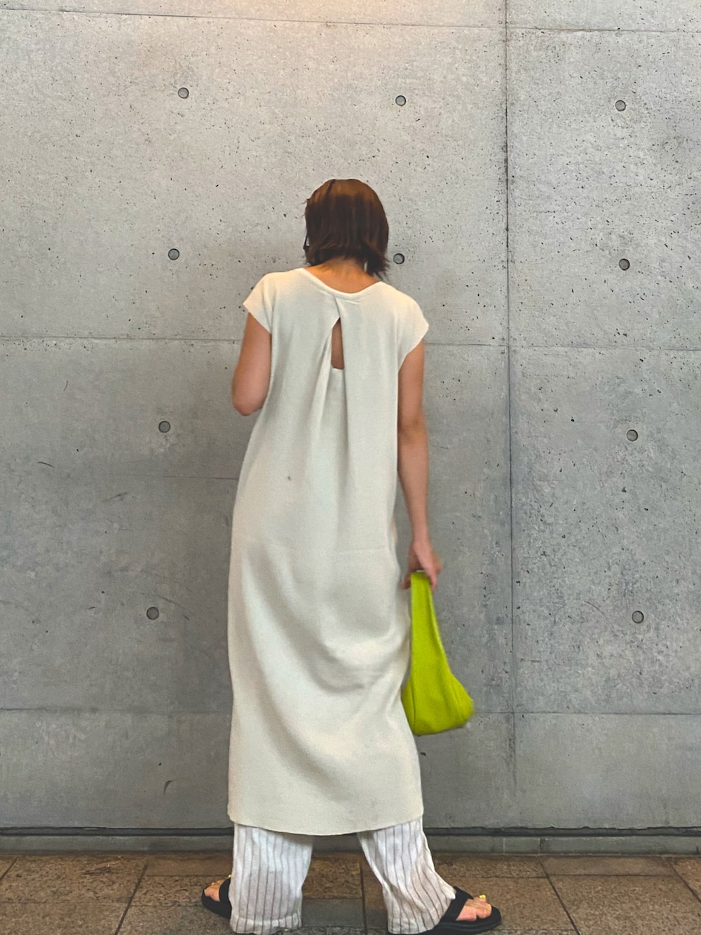 ホワイト系のワンピース、グリーン系のハンドバッグ、ベージュ系のその他パンツを着用したレディースの夏コーディネートの2枚目の写真