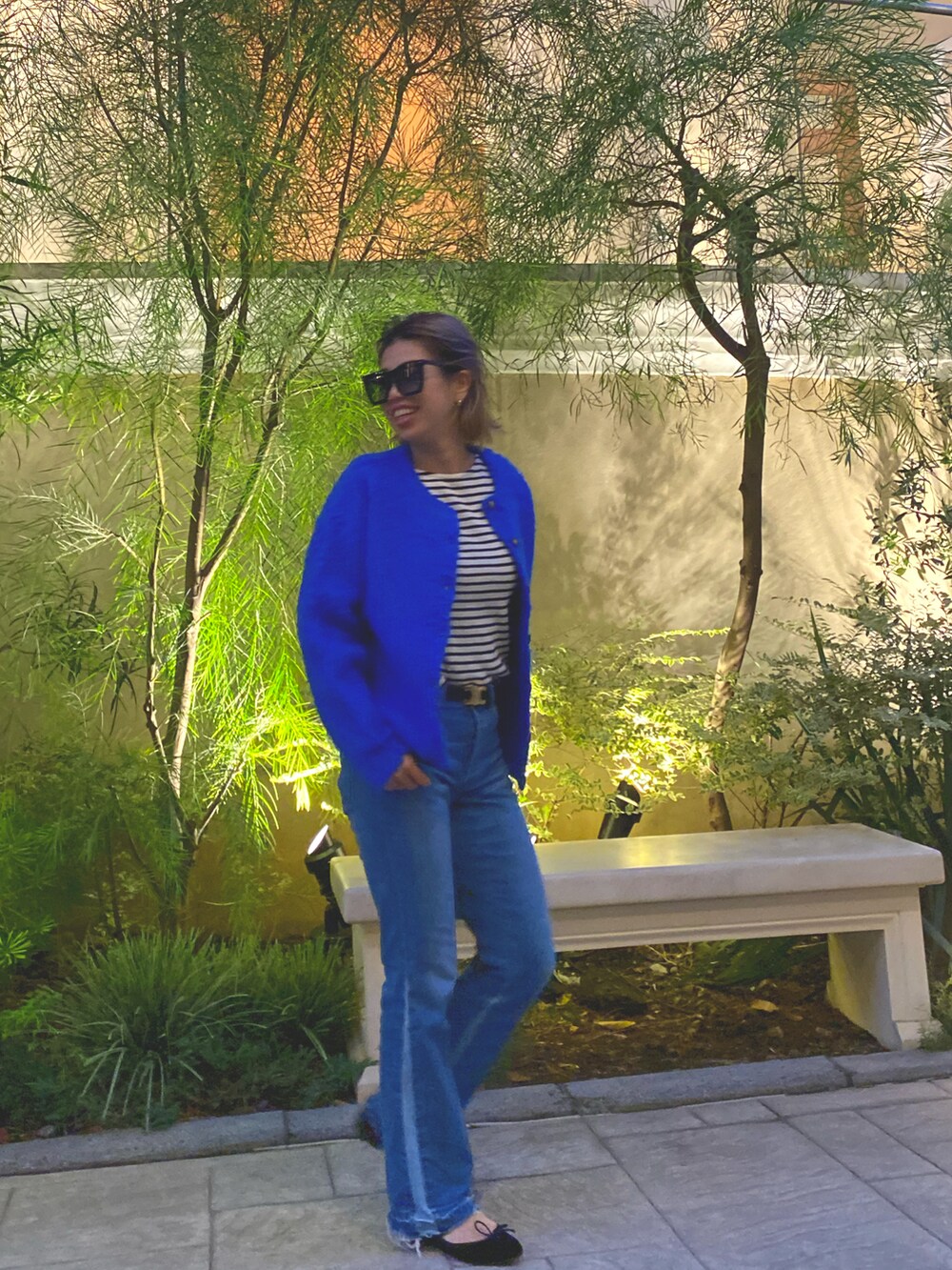 ブルー系のカーディガン/ボレロ、グリーン系のハンドバッグ、ブルー系のデニムパンツを着用したレディースの秋コーディネートの2枚目の写真