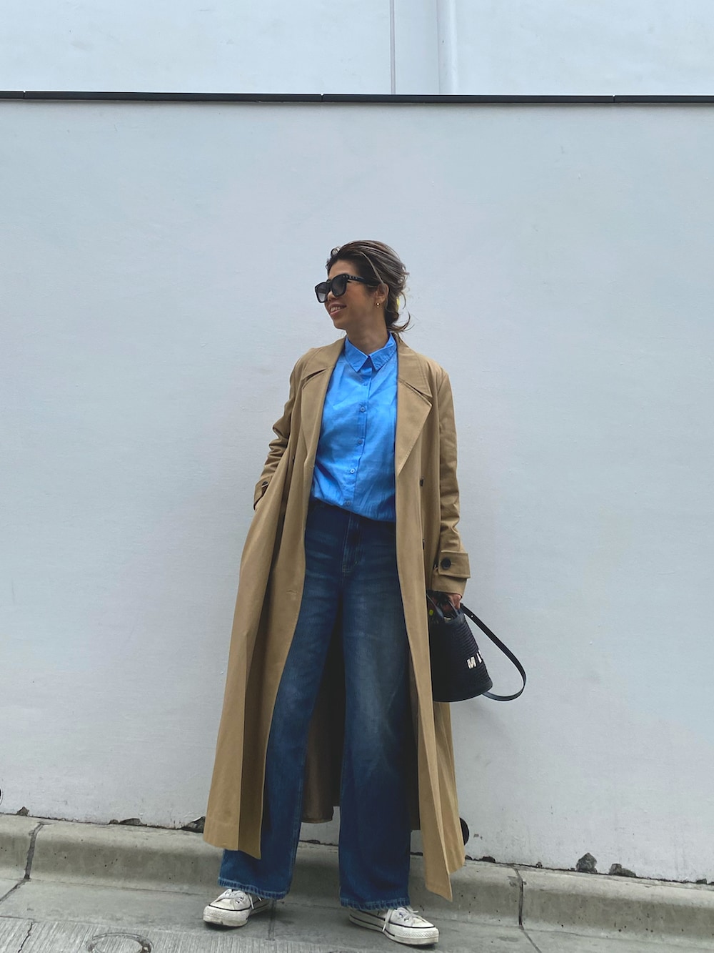 ブルー系のシャツ/ブラウス、ブルー系のデニムパンツ、ブラック系のショルダーバッグを着用したレディースの春コーディネートの2枚目の写真