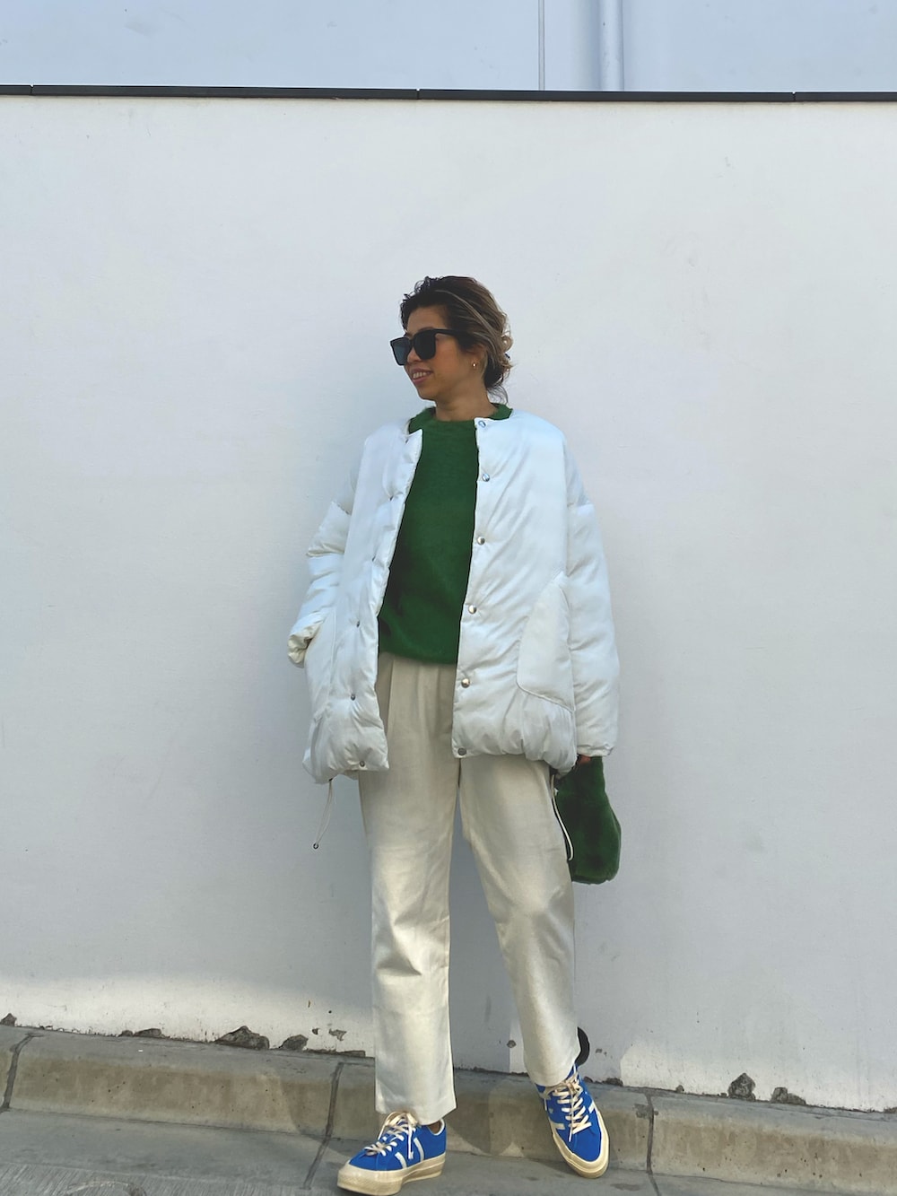 ホワイト系のノーカラージャケット、グリーン系のニット/セーター、ベージュ系のその他パンツを着用したレディースの冬コーディネートの2枚目の写真