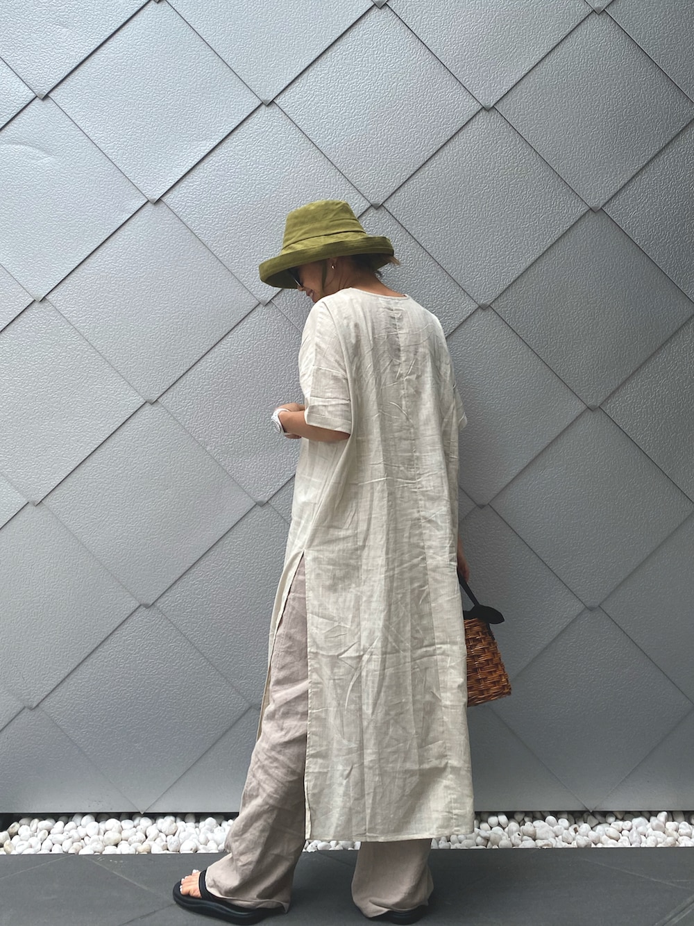 ベージュ系のワンピース、ホワイト系のかごバッグ、グレー系のその他パンツを着用したレディースの夏コーディネートの2枚目の写真