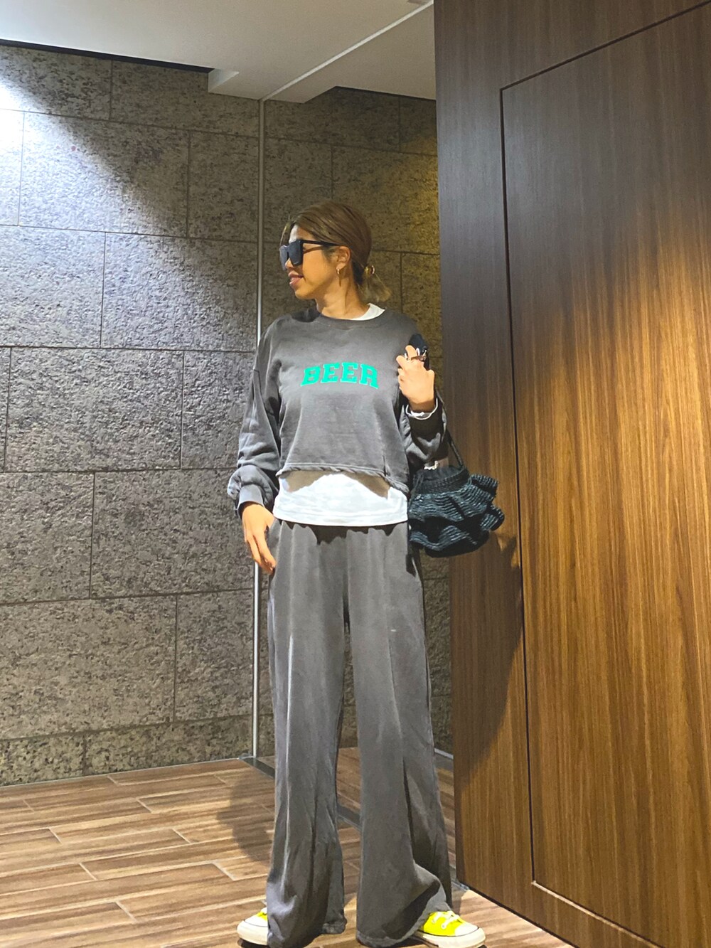 グレー系のスウェット、ホワイト系のTシャツ/カットソー、ブラック系のかごバッグを着用したレディースの春コーディネートの3枚目の写真