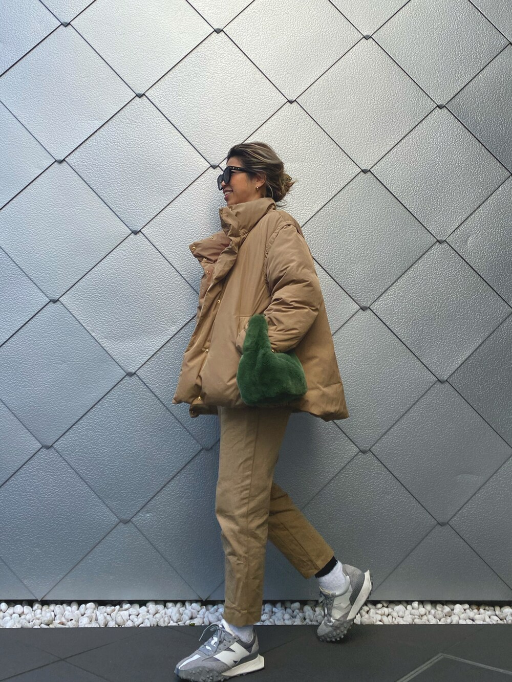 イエロー系のダウンジャケット/コート、ピンク系のスウェット、ベージュ系のその他パンツを着用したレディースの冬コーディネートの2枚目の写真