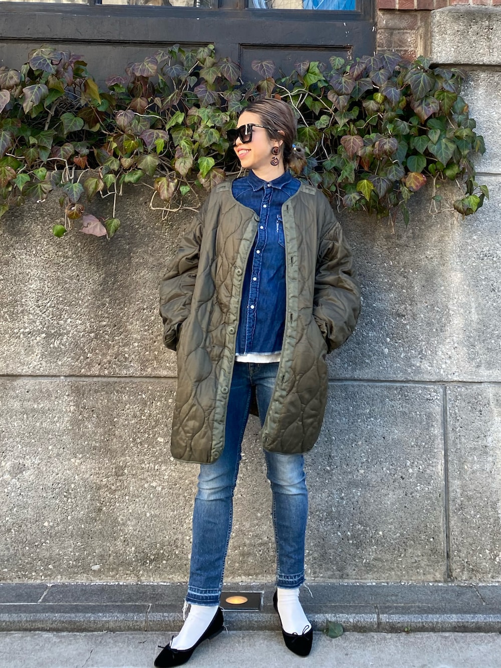 グリーン系のモッズコート、ブラック系のバレエシューズ、ホワイト系のレギンス/スパッツを着用したレディースの春コーディネートの2枚目の写真