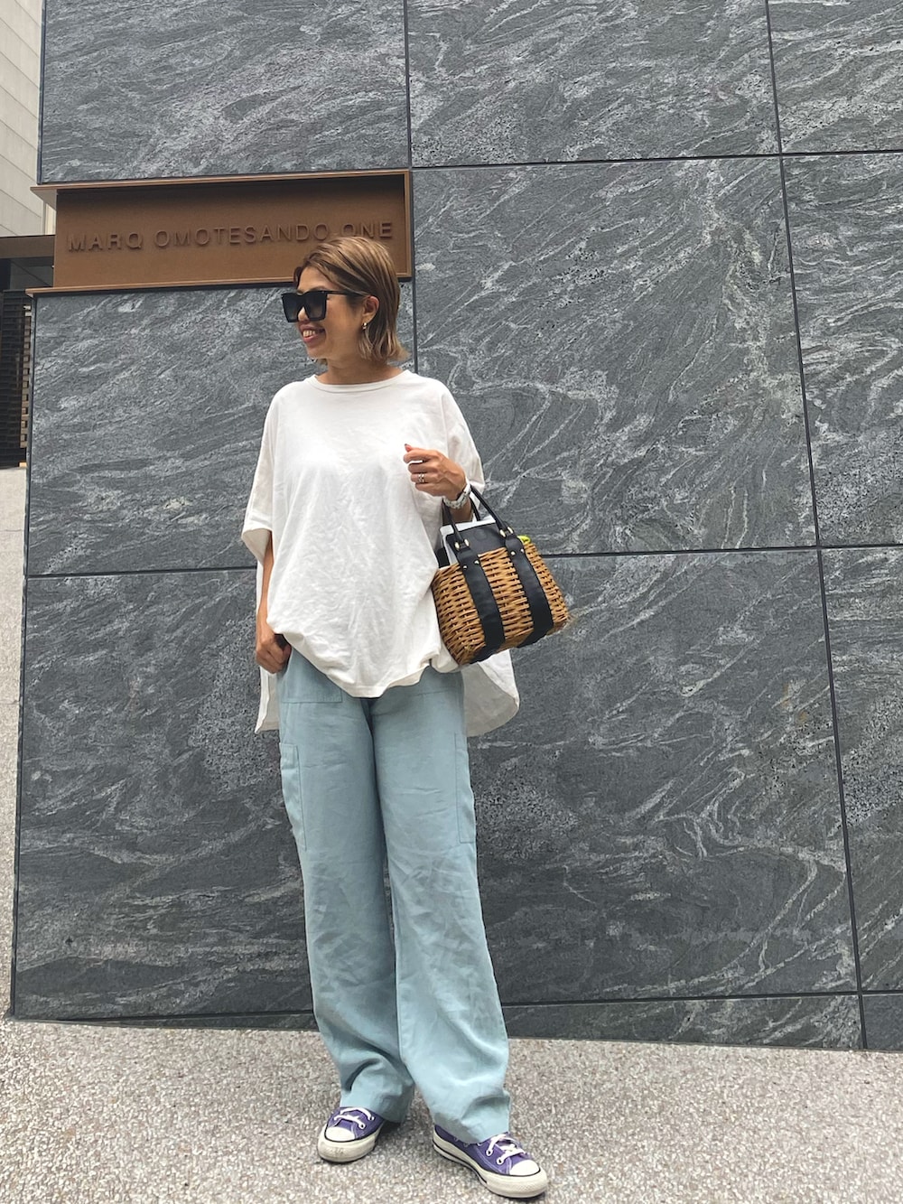 ホワイト系のTシャツ/カットソー、ブルー系のカーゴパンツ、ブラック系のかごバッグを着用したレディースの夏コーディネートの2枚目の写真