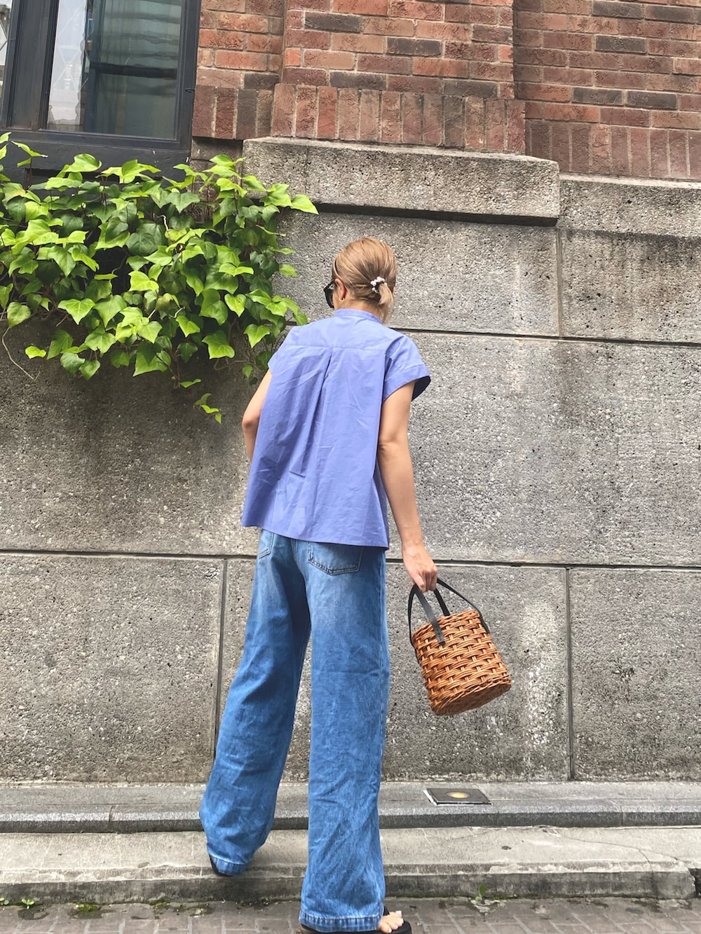 ブルー系のシャツ/ブラウス、ブルー系のデニムパンツ、ホワイト系のかごバッグを着用したレディースの夏コーディネートの2枚目の写真