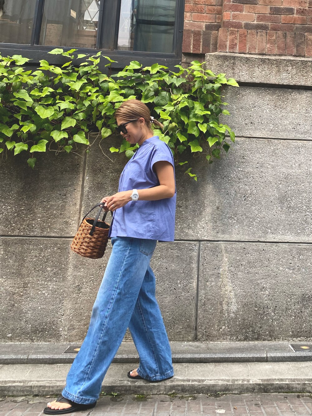 ブルー系のシャツ/ブラウス、ブルー系のデニムパンツ、ホワイト系のかごバッグを着用したレディースの夏コーディネートの3枚目の写真