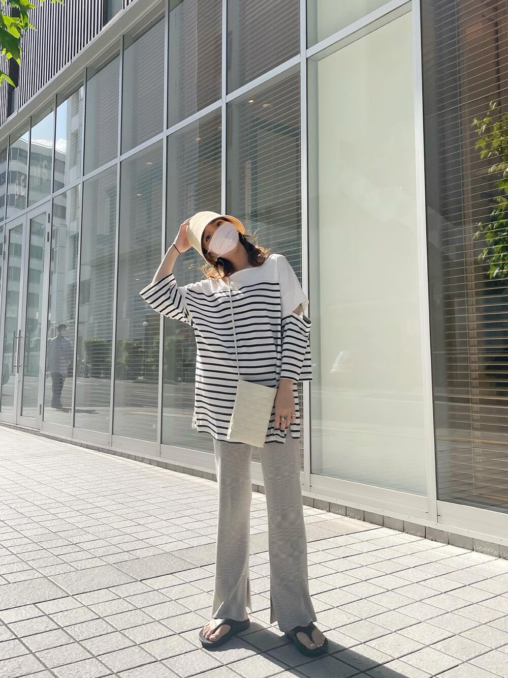 ブラック系のサンダル、ホワイト系のショルダーバッグ、ベージュ系のその他パンツを着用したレディースの夏コーディネートの3枚目の写真