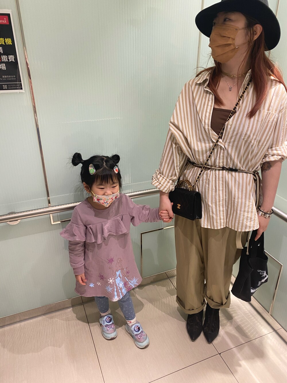 ベージュ系のトップス、ブラック系のバッグ、ブラック系のクラッチバッグを着用したレディースの春コーディネートの2枚目の写真