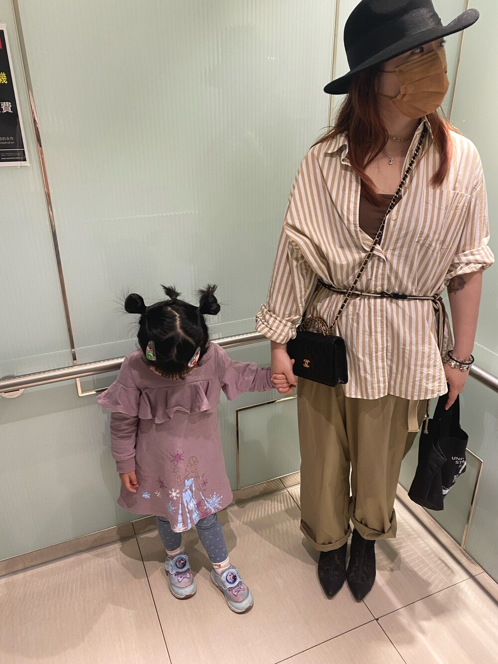 ベージュ系のトップス、ブラック系のバッグ、ブラック系のクラッチバッグを着用したレディースの春コーディネートの3枚目の写真