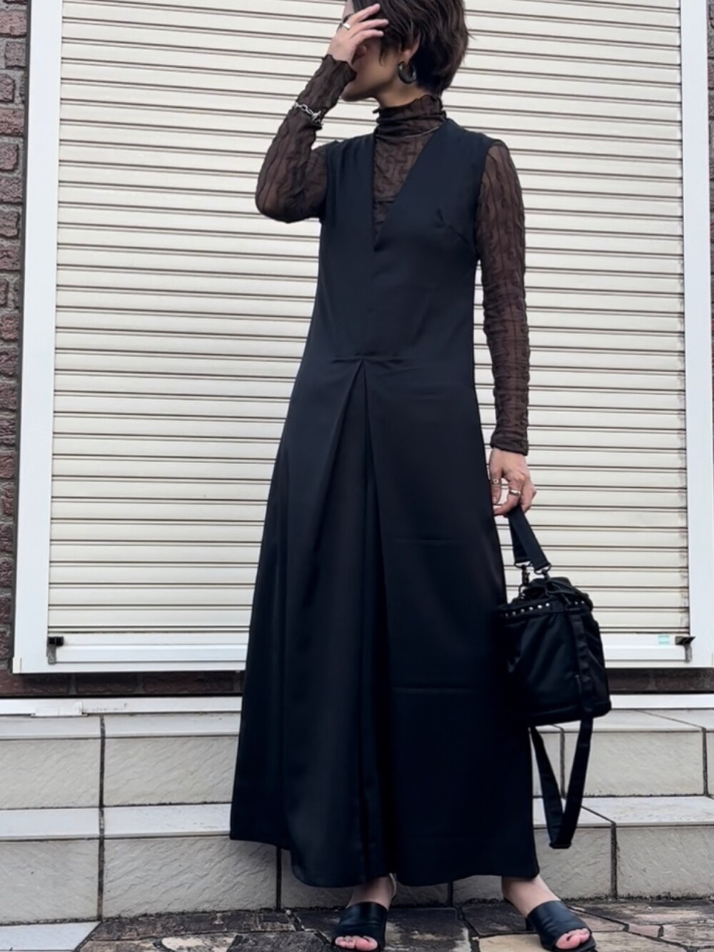 ブラック系のベスト、ブラウン系のTシャツ/カットソー、ブラック系のショルダーバッグを着用したレディースの秋コーディネートの2枚目の写真