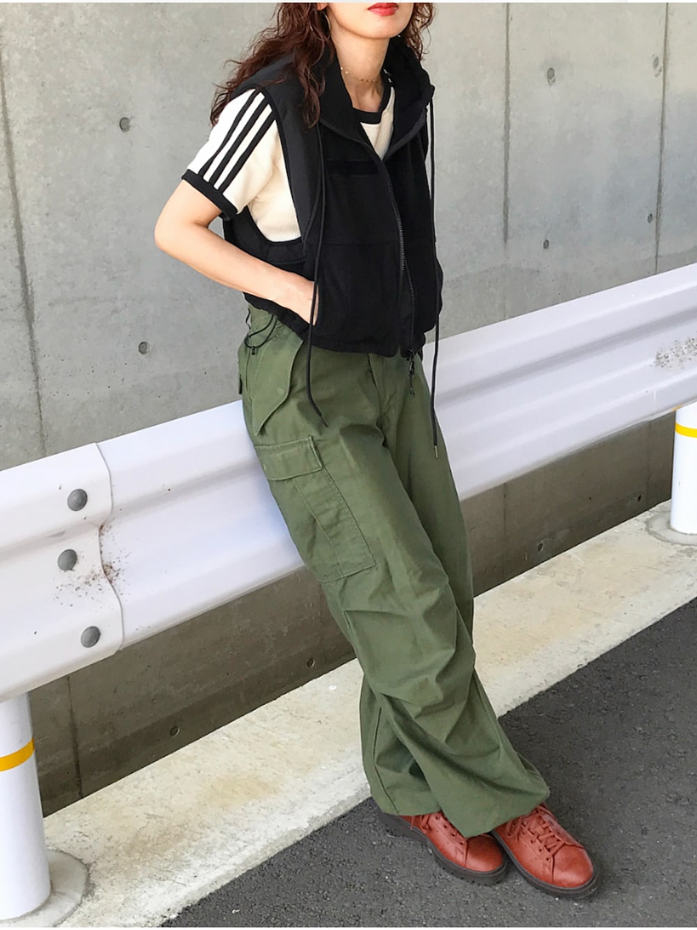 ブラック系のベスト、ホワイト系のTシャツ/カットソー、グリーン系のカーゴパンツを着用したレディースの夏コーディネートの2枚目の写真