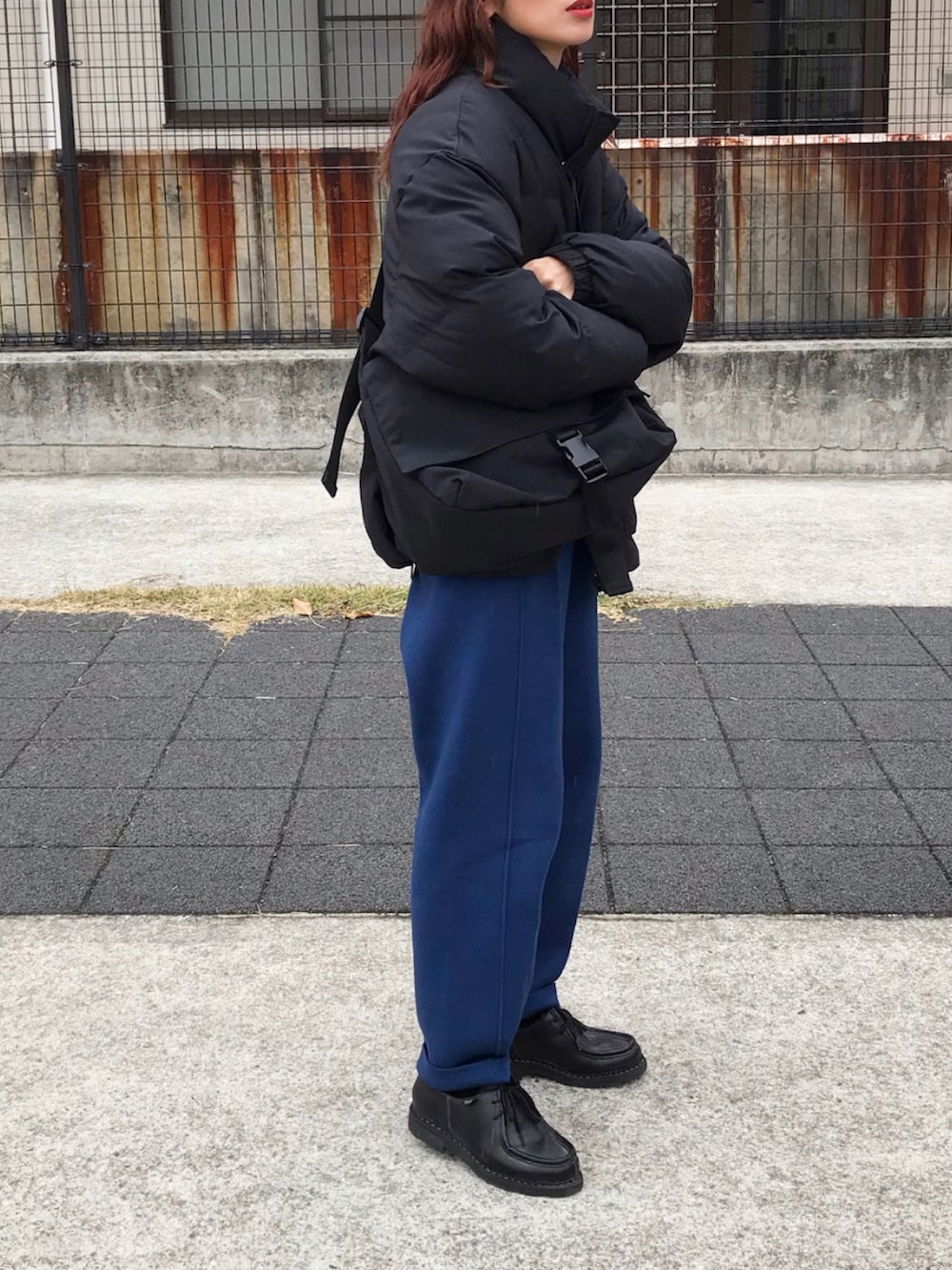 ブラック系のダウンジャケット/コート、ブルー系のパンツ、ブラック系のショルダーバッグを着用したレディースの冬コーディネートの2枚目の写真