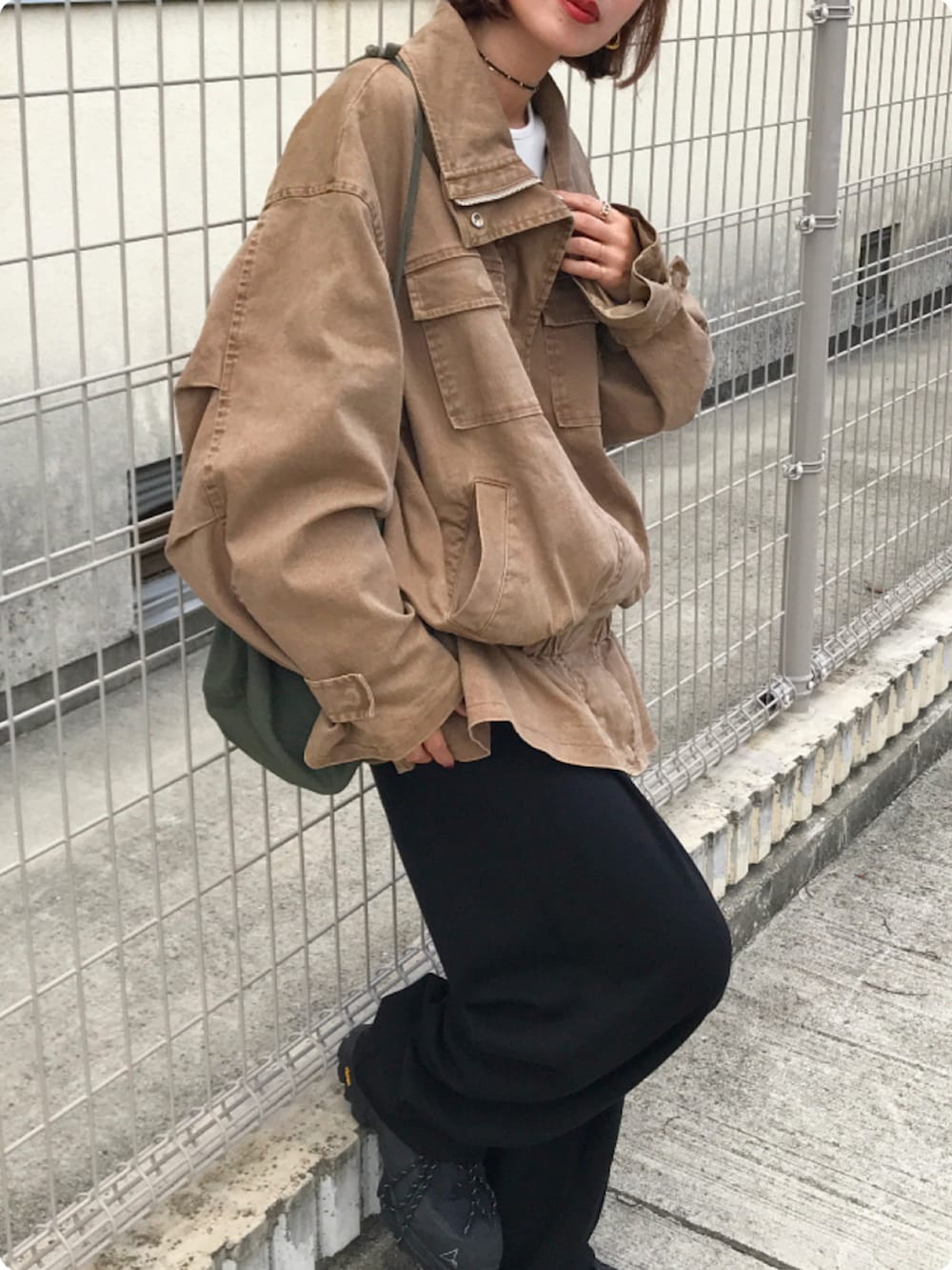 ブラウン系のブルゾン、ホワイト系のTシャツ/カットソー、ブラック系のスウェットパンツを着用したレディースの秋コーディネートの2枚目の写真