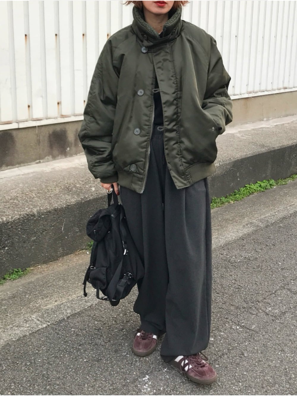 ブラック系のバックパック/リュック、ブラウン系のスニーカー、ブラック系のニット/セーターを着用したレディースの冬コーディネートの2枚目の写真