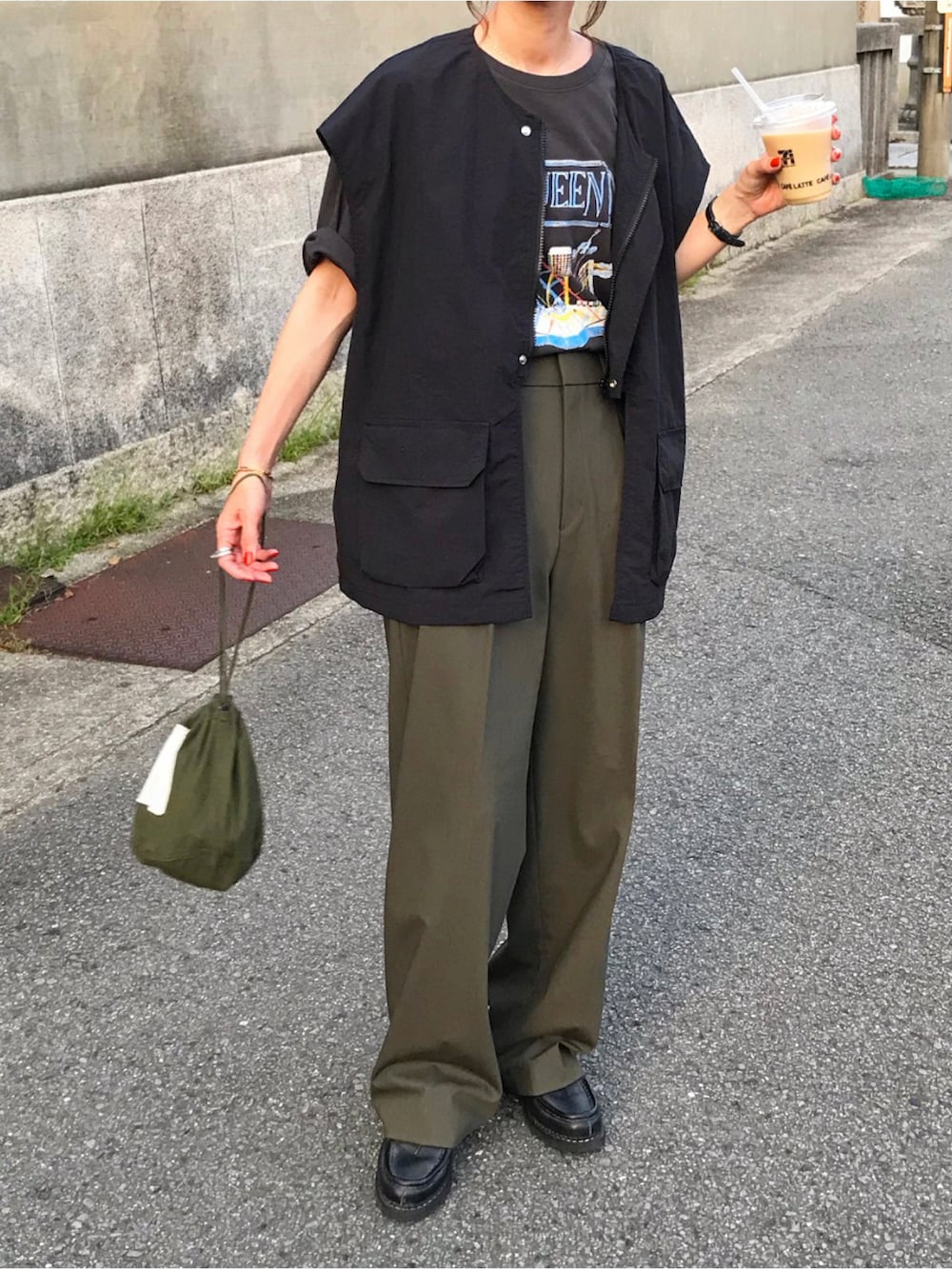 ブラック系のベスト、ブラック系のTシャツ/カットソー、グリーン系のパンツを着用したレディースの夏コーディネートの2枚目の写真