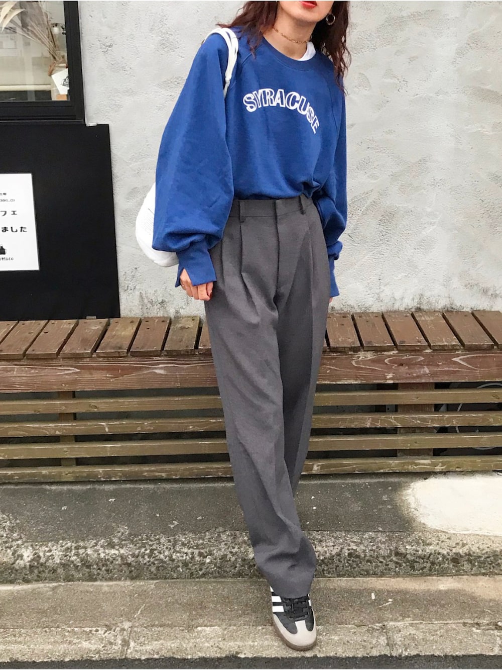 ブルー系のスウェット、グリーン系のショルダーバッグ、グレー系のスラックスを着用したレディースの秋コーディネートの2枚目の写真