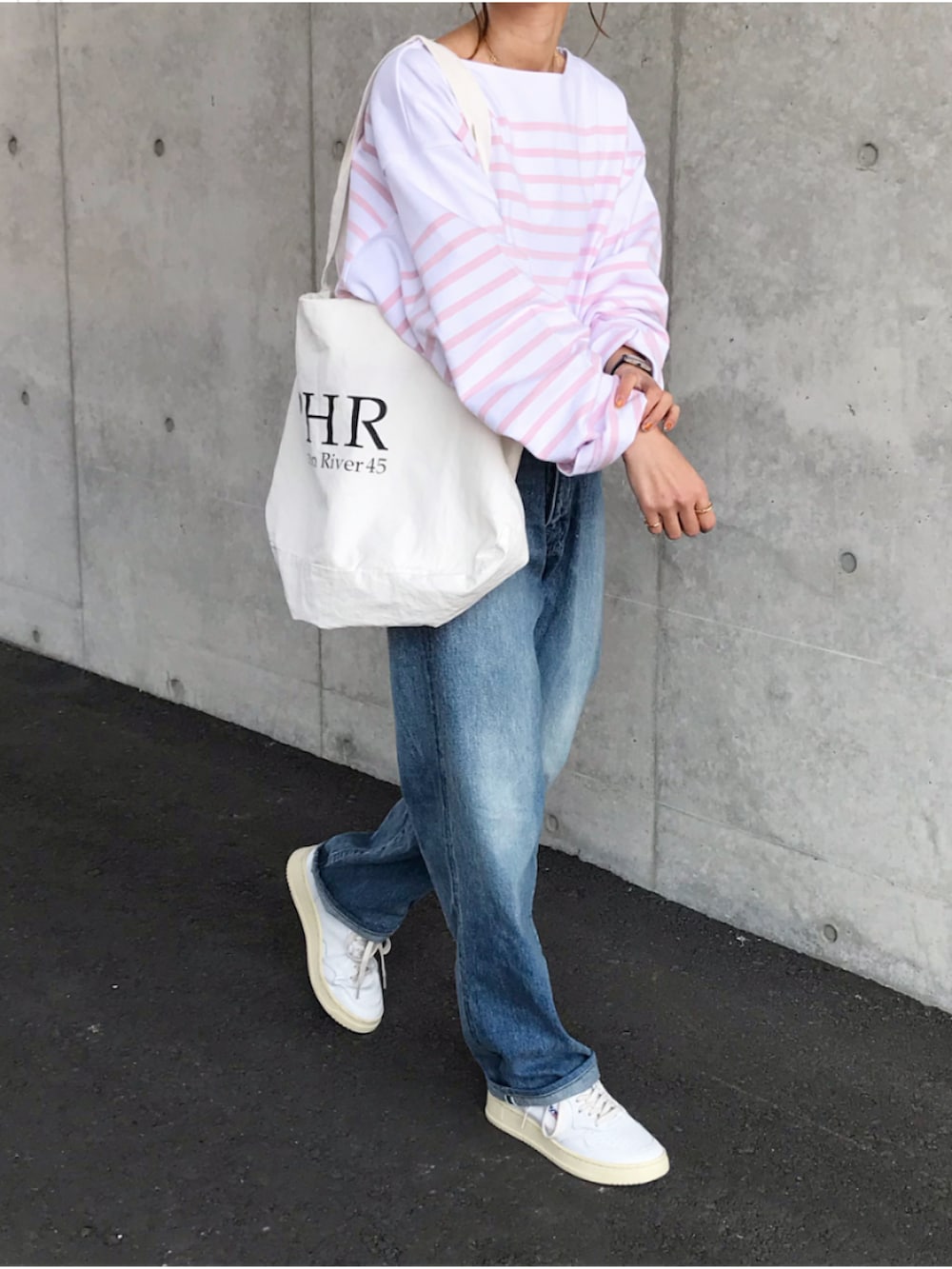 ピンク系のTシャツ/カットソー、ブルー系のデニムパンツ、ブラック系のボストンバッグを着用したレディースの春コーディネートの2枚目の写真