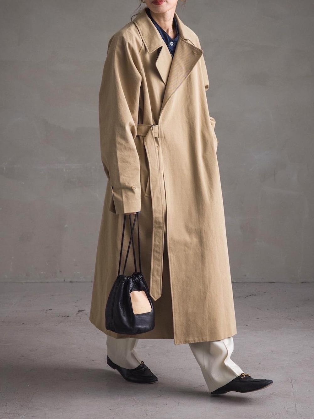 ベージュ系のトレンチコート、ブルー系のシャツ/ブラウス、ホワイト系のパンツを着用したレディースの冬コーディネートの3枚目の写真