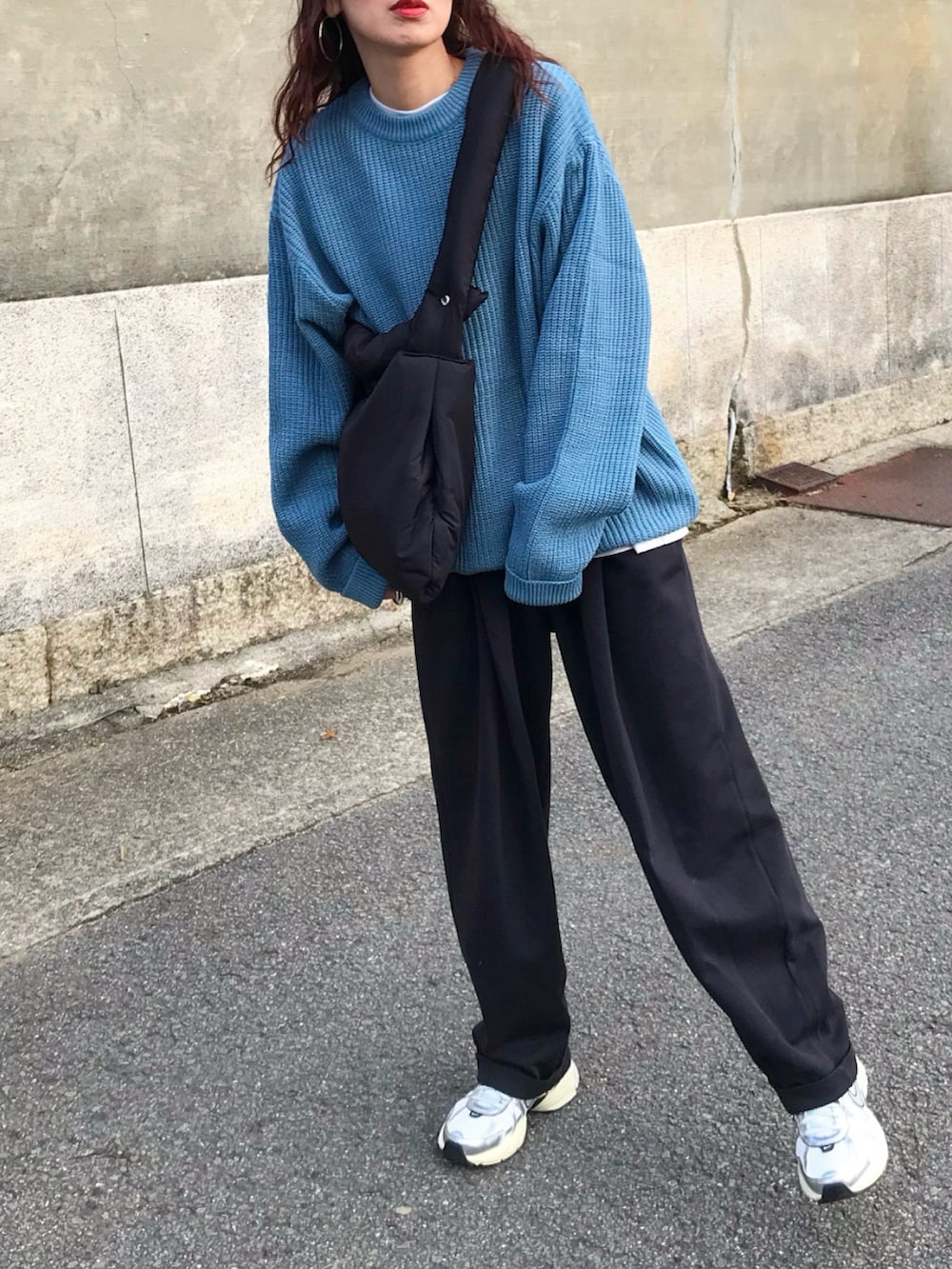 ブルー系のニット/セーター、ホワイト系のTシャツ/カットソー、ブラック系のパンツを着用したレディースの冬コーディネートの2枚目の写真