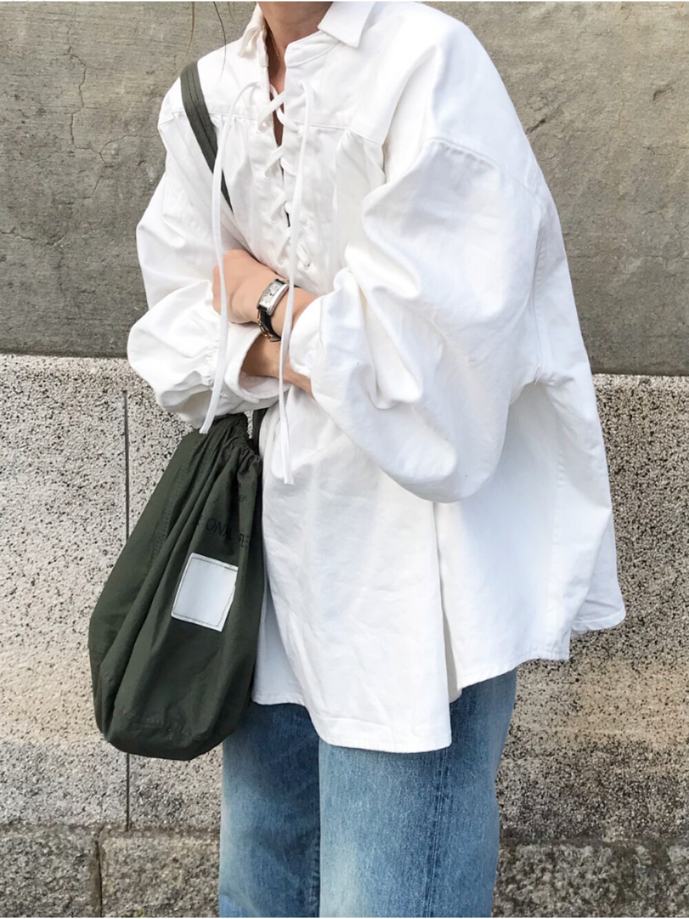 ホワイト系のシャツ/ブラウス、ブルー系のデニムパンツ、グリーン系のバッグを着用したレディースの春コーディネートの2枚目の写真