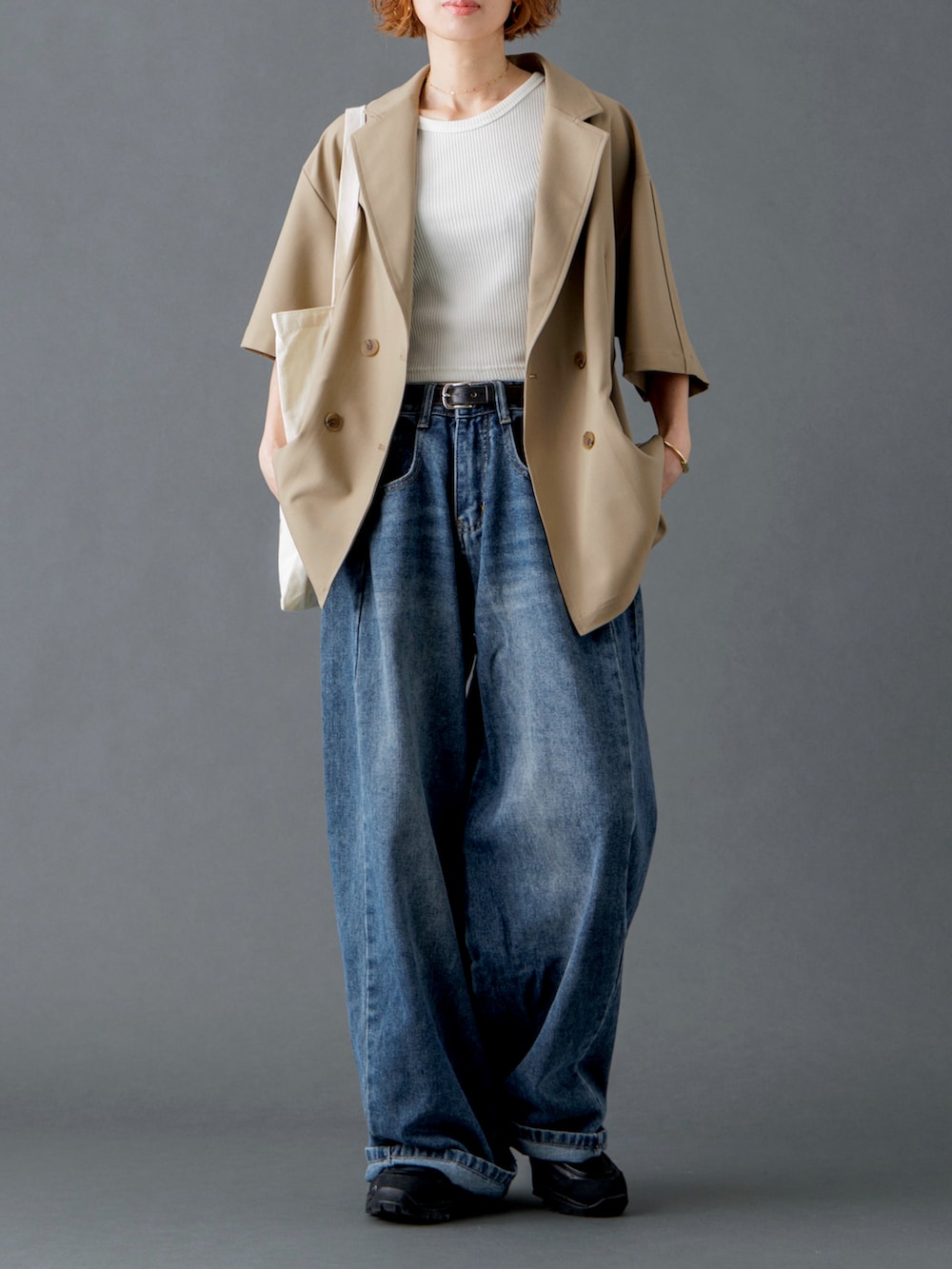 ベージュ系のテーラードジャケット、ブルー系のデニムパンツ、ホワイト系のトートバッグを着用したレディースの春コーディネートの3枚目の写真